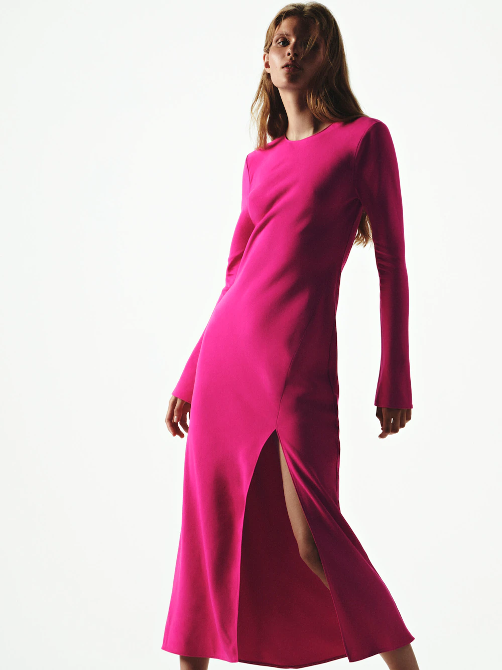 Massimo Dutti fuchsia Flowing fabric midi dress with long sleeves. It has a crew neck and a slit at the thigh. It closes with a zip fastening at the back. It has buttoned cuffs.
