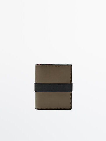 Skórzany portfel z kontrastowym, elastycznym elementem.