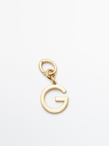 Gylden charm i form af bogstavet G