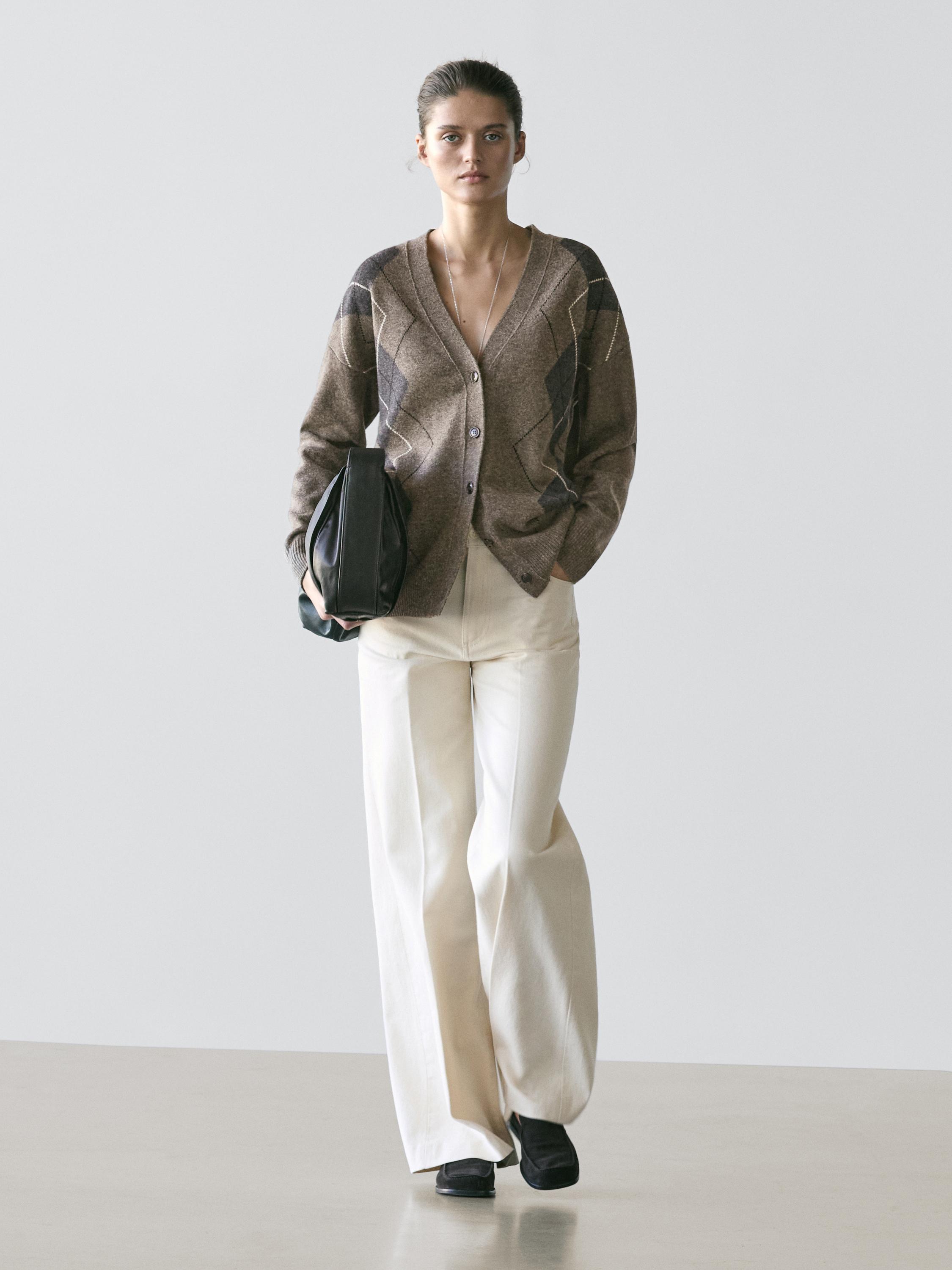 Taupe argyle cardigan set with white wide-leg pants. Visible side pocket on the cardigan.