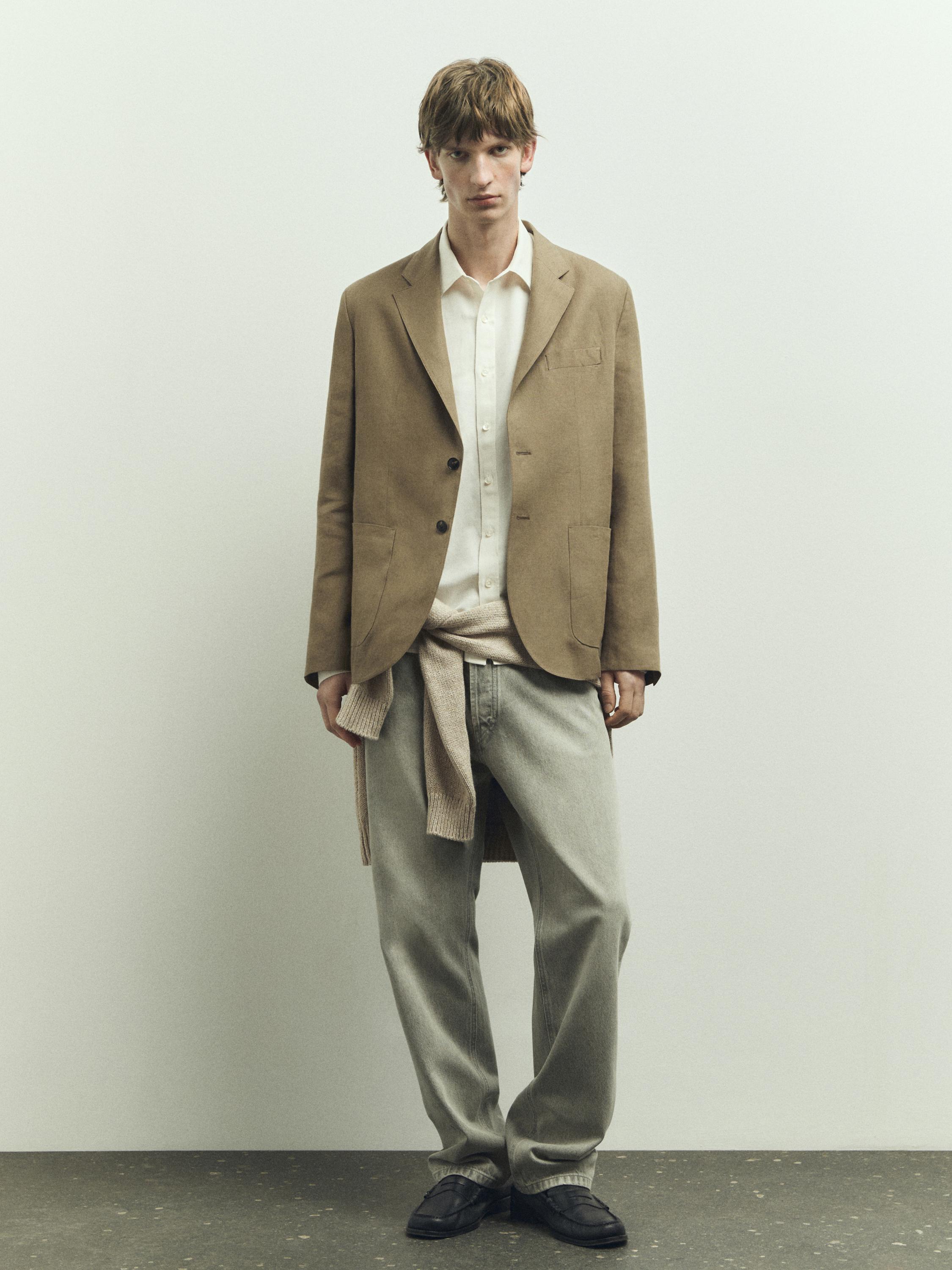 갈색 재킷, 흰색 셔츠, 회색 바지, 검은색 신발 세트. 허리에 묶은 베이지색 스웨터.