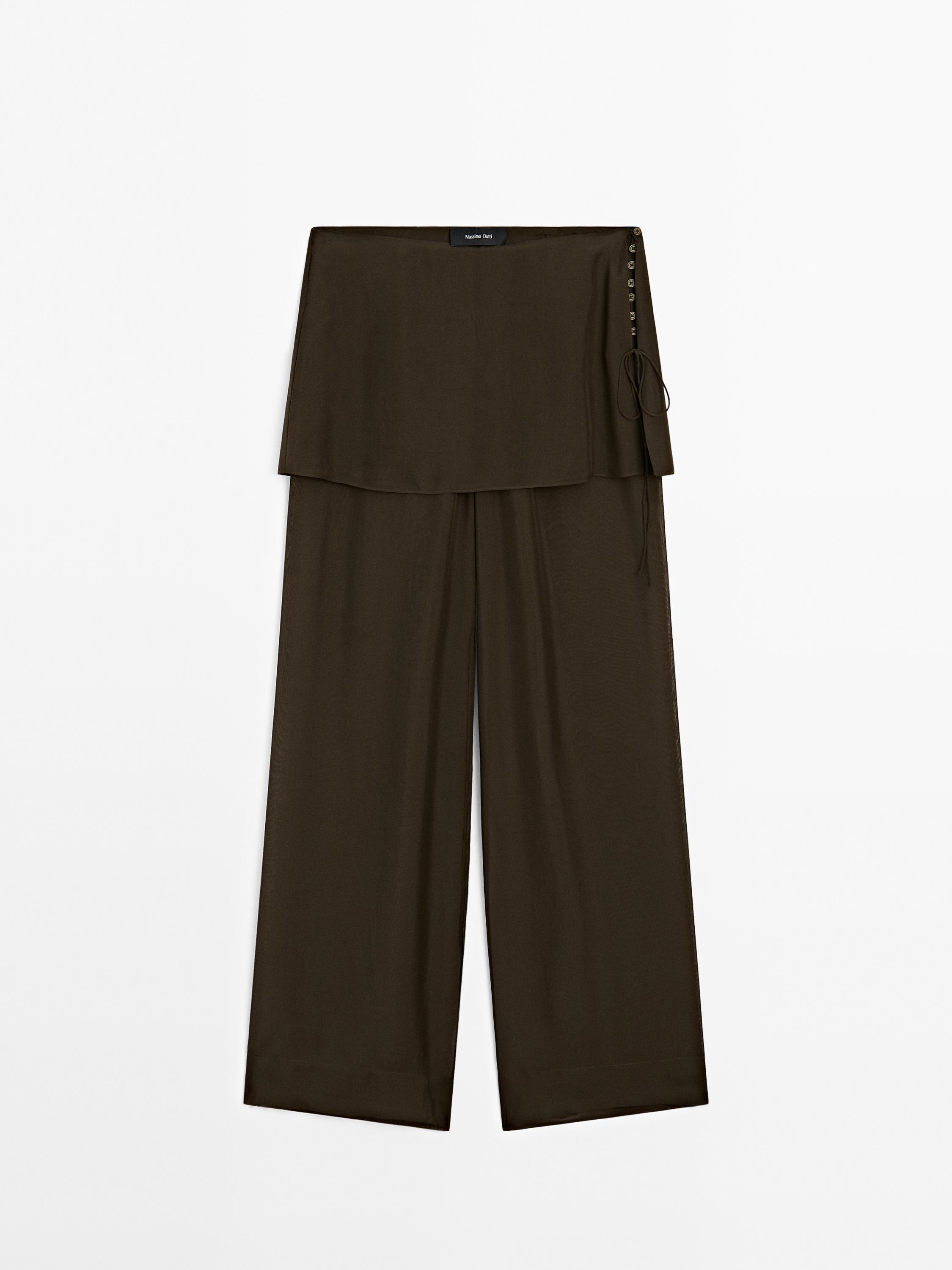 Front view of wide-leg brown trousers with buttons and tie at the waist.