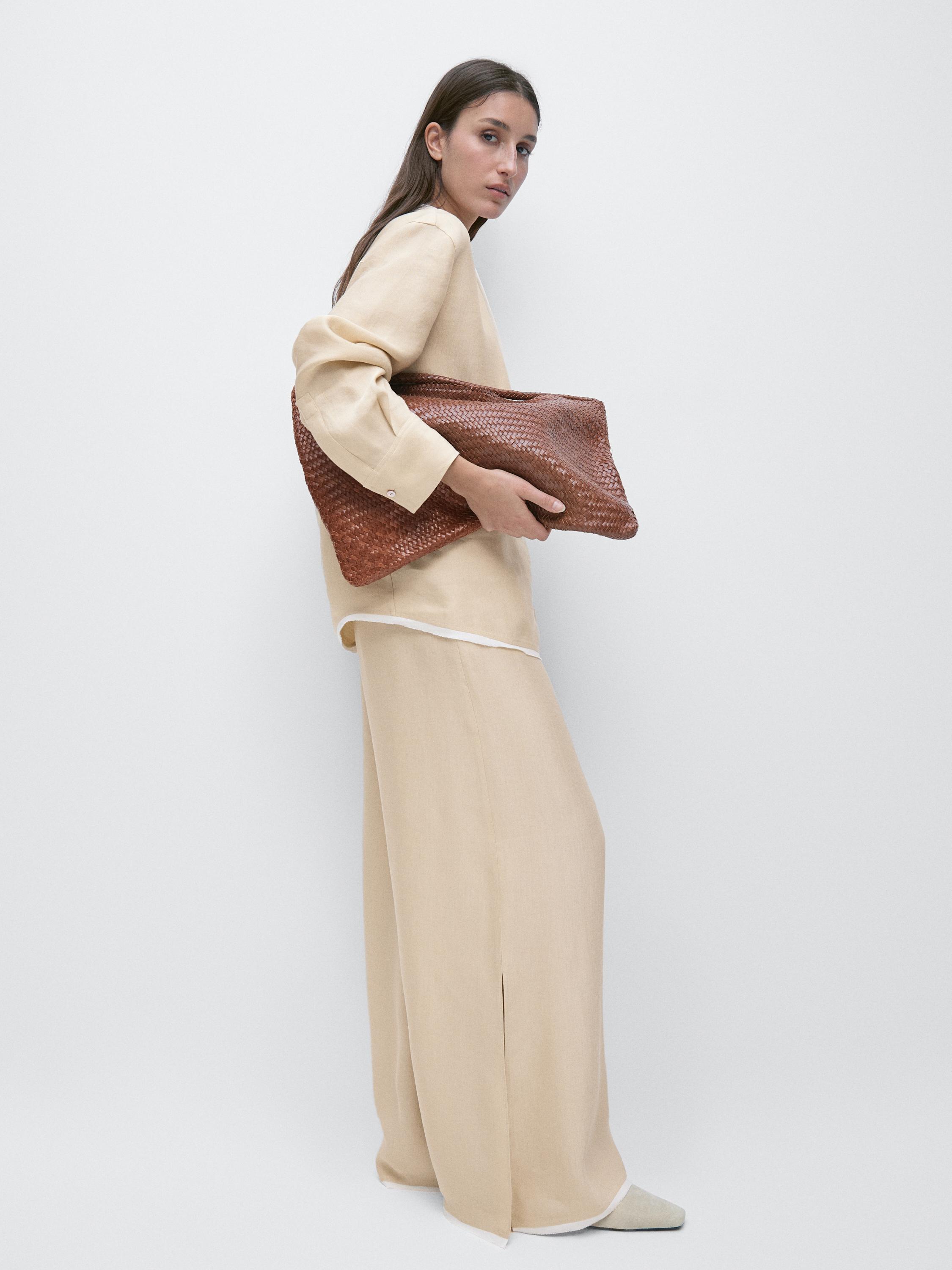 Bol kesim bej bluz ve pantolon takımı, pantolonda yan yırtmaç detayı.