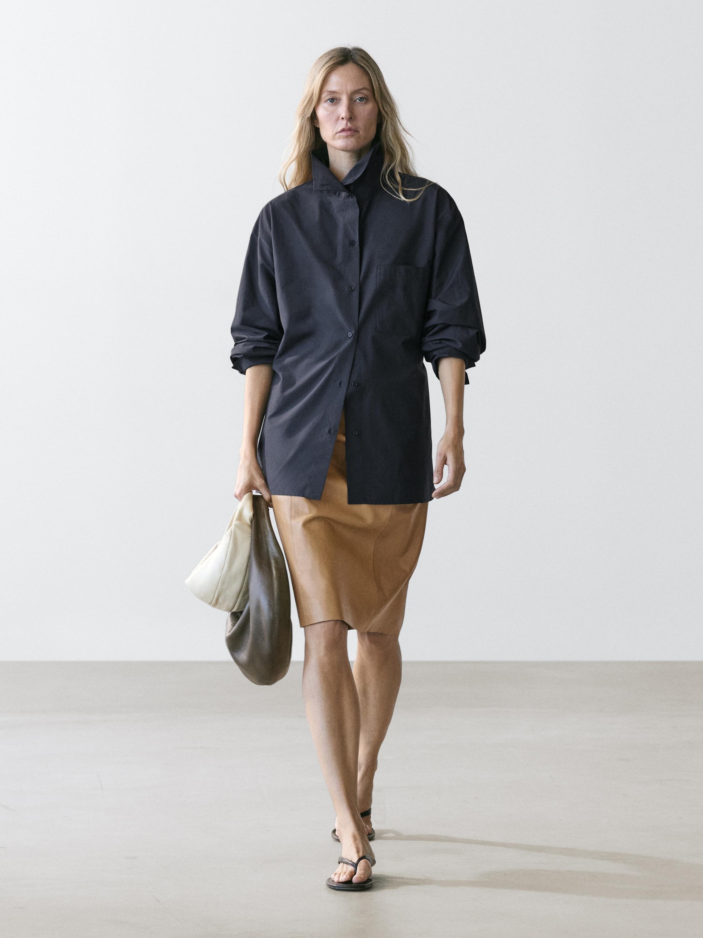 Ensemble surchemise bleu profond avec boutons et poche avant, jupe marron et sandales noires.