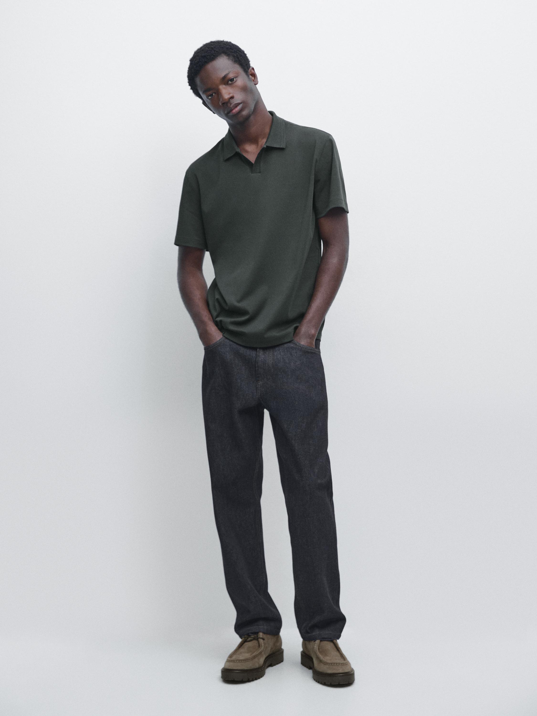 Ensemble polo vert bouteille à manches courtes et pantalon droit foncé.