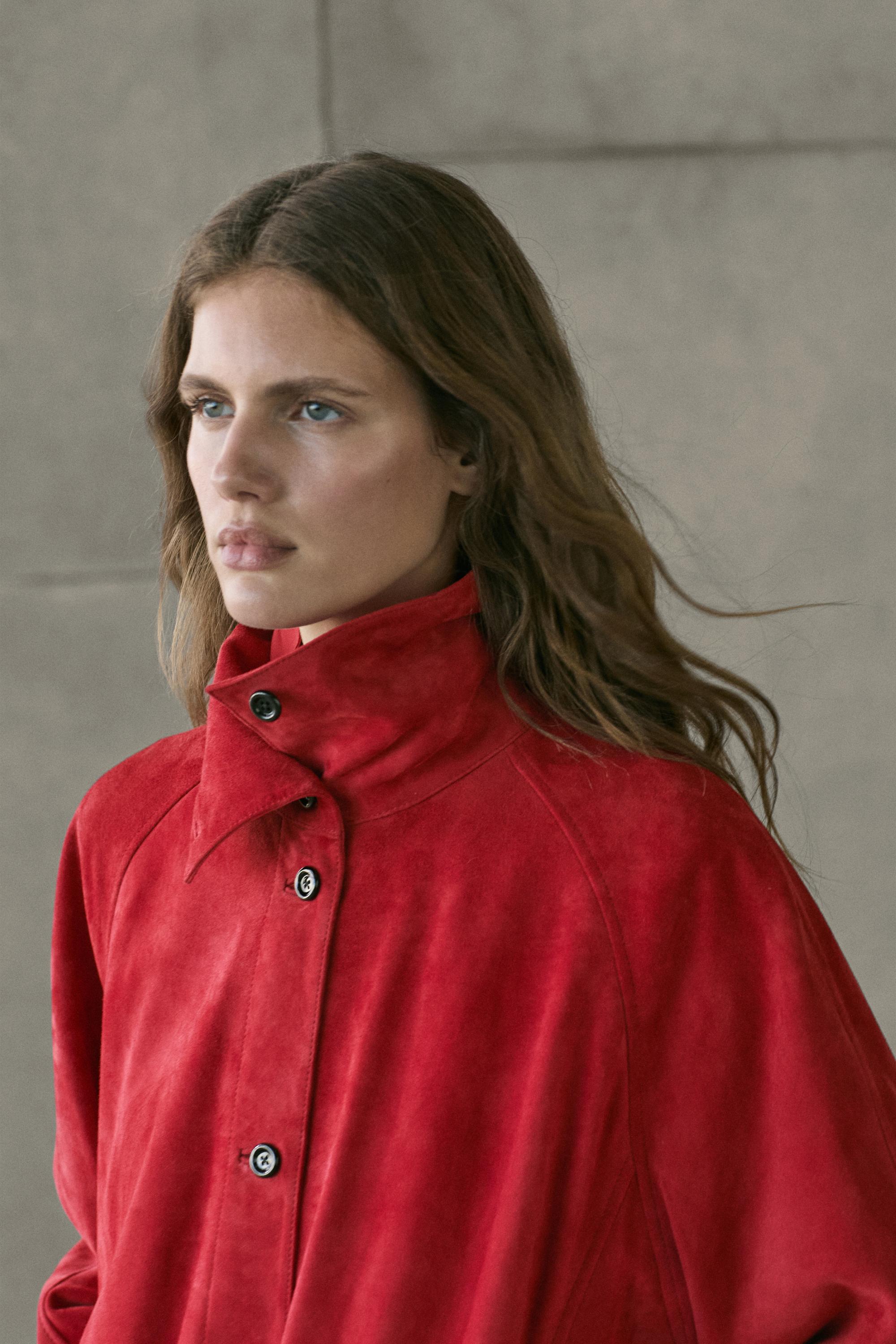 Plano medio de chaqueta bomber roja con cuello alto y botonadura frontal.