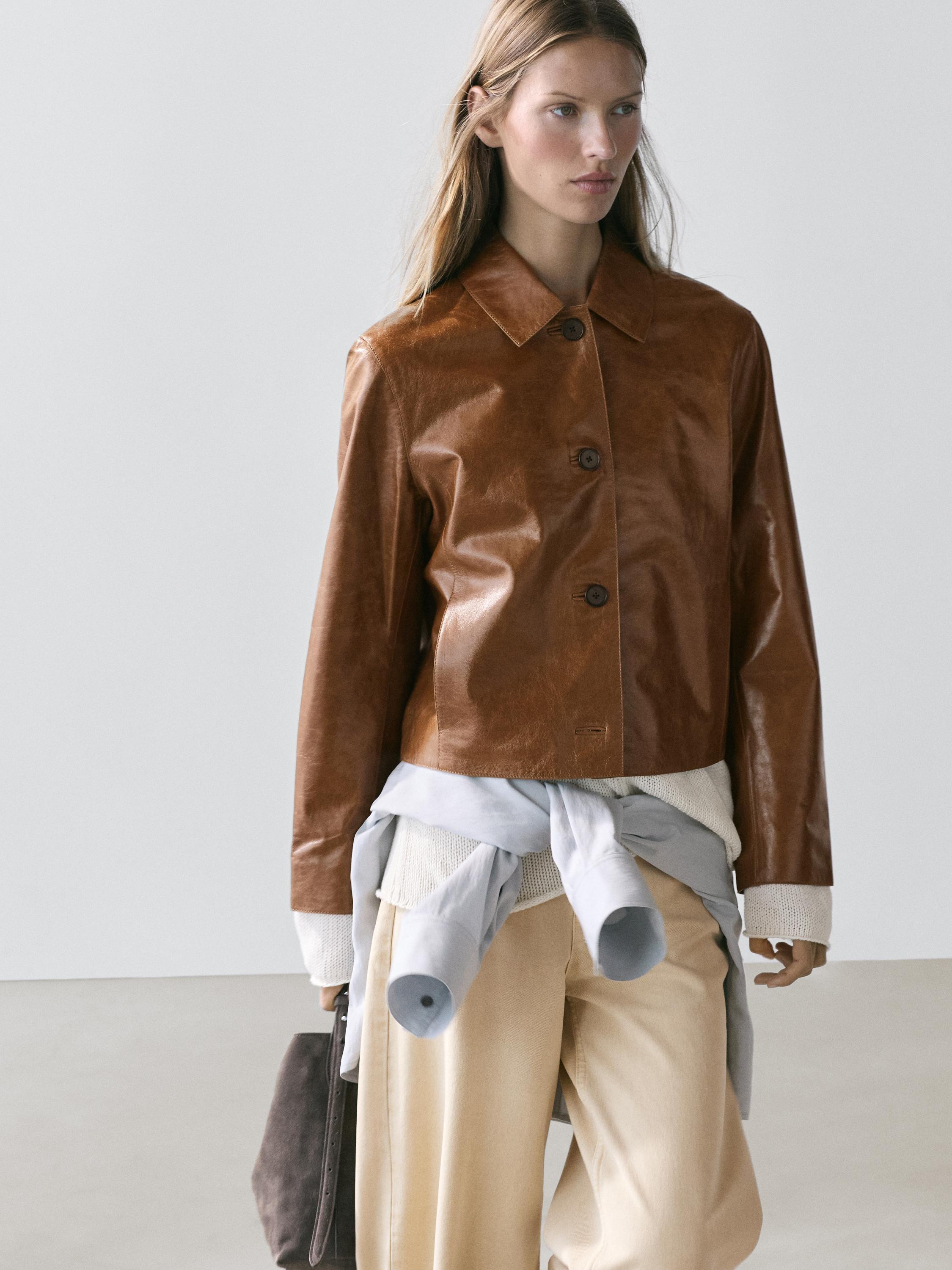 Camel bomber jacket set with buttons, beige pants, and gray sweater tied at the waist.