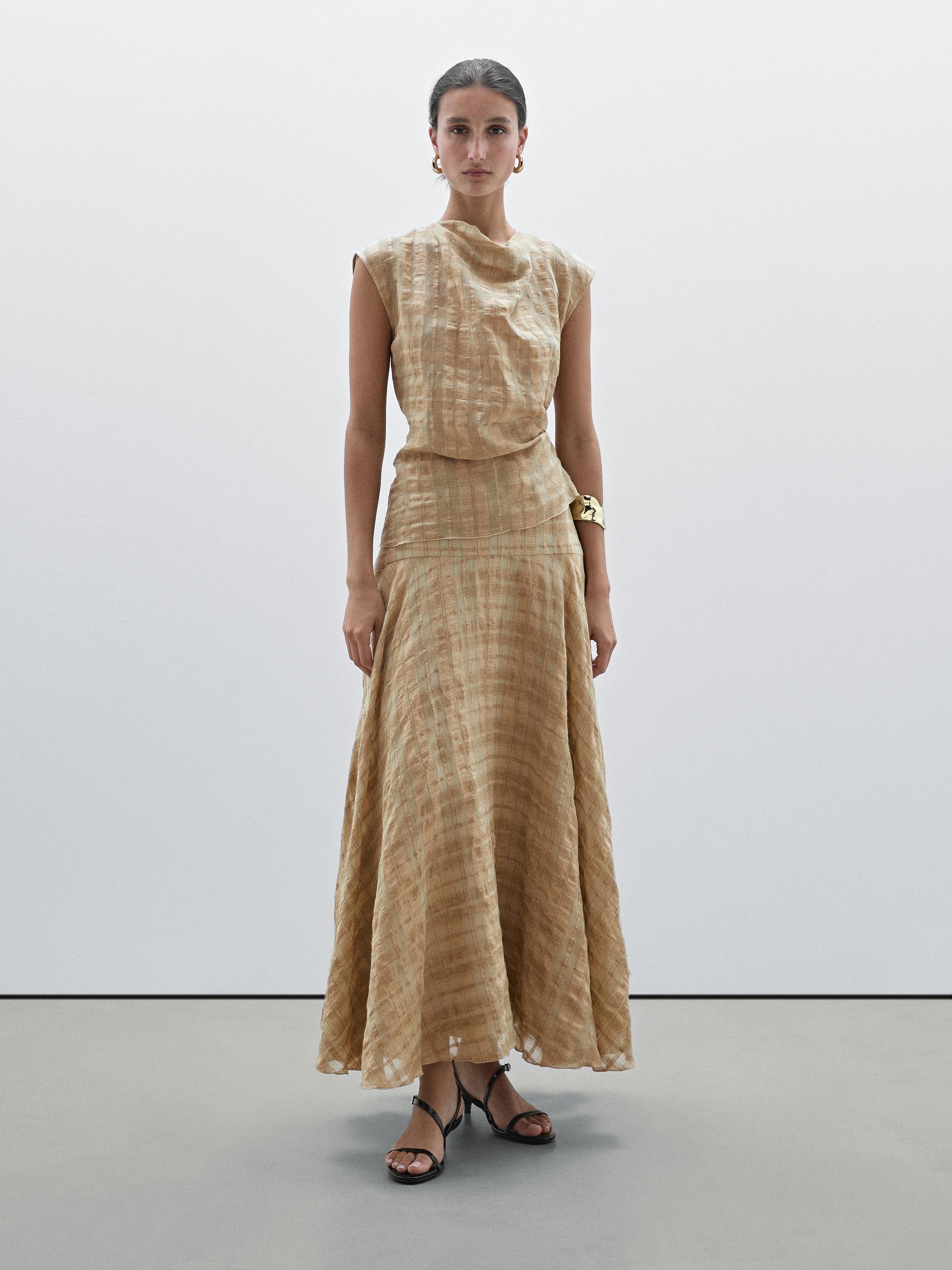 طقم بلوزة بدون أكمام وتنورة طويلة بلون بيج وملمس، منظر أمامي.