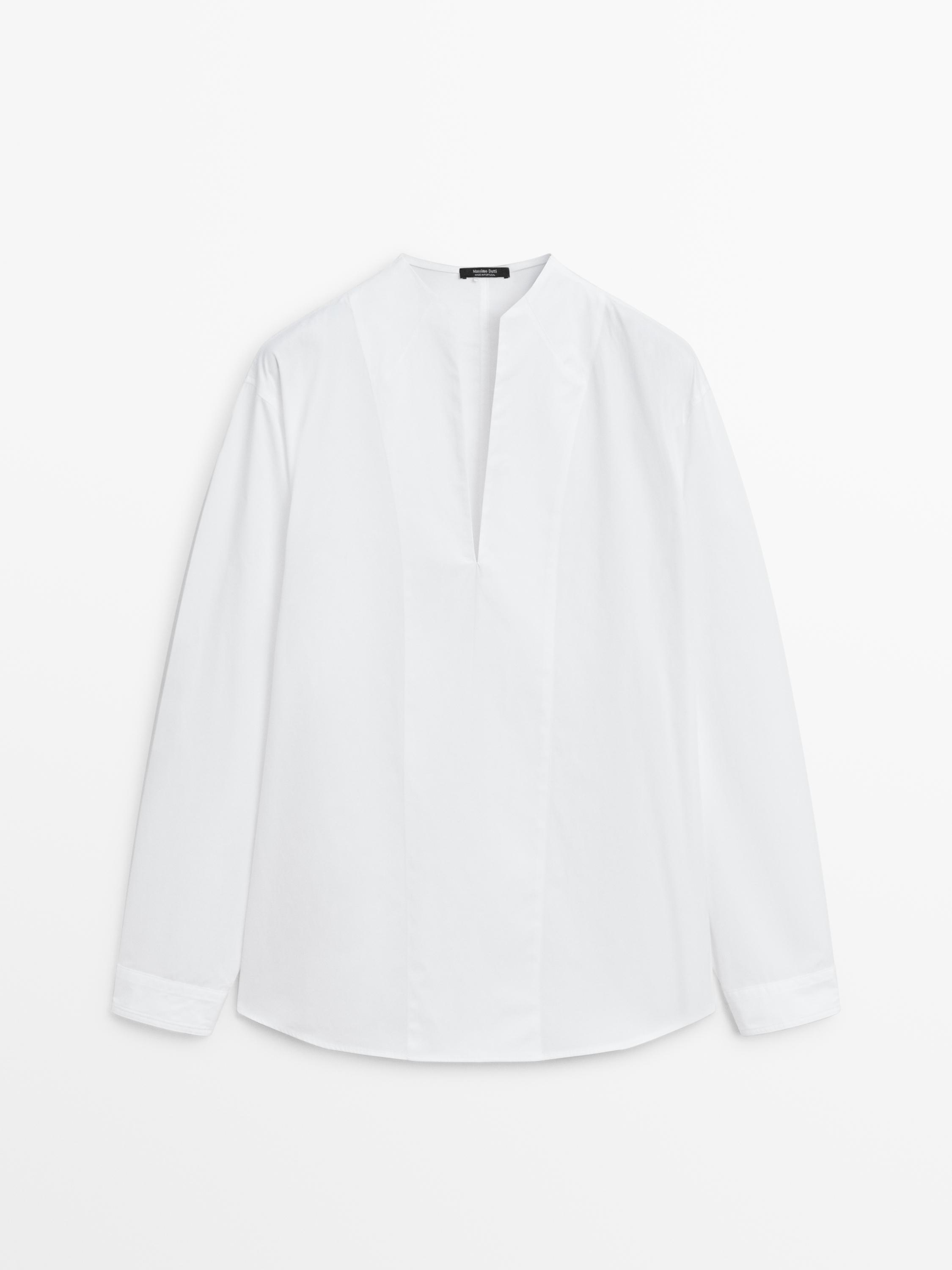 Front view of white shirt with mandarin collar and bib detail. Long sleeves and straight cut.