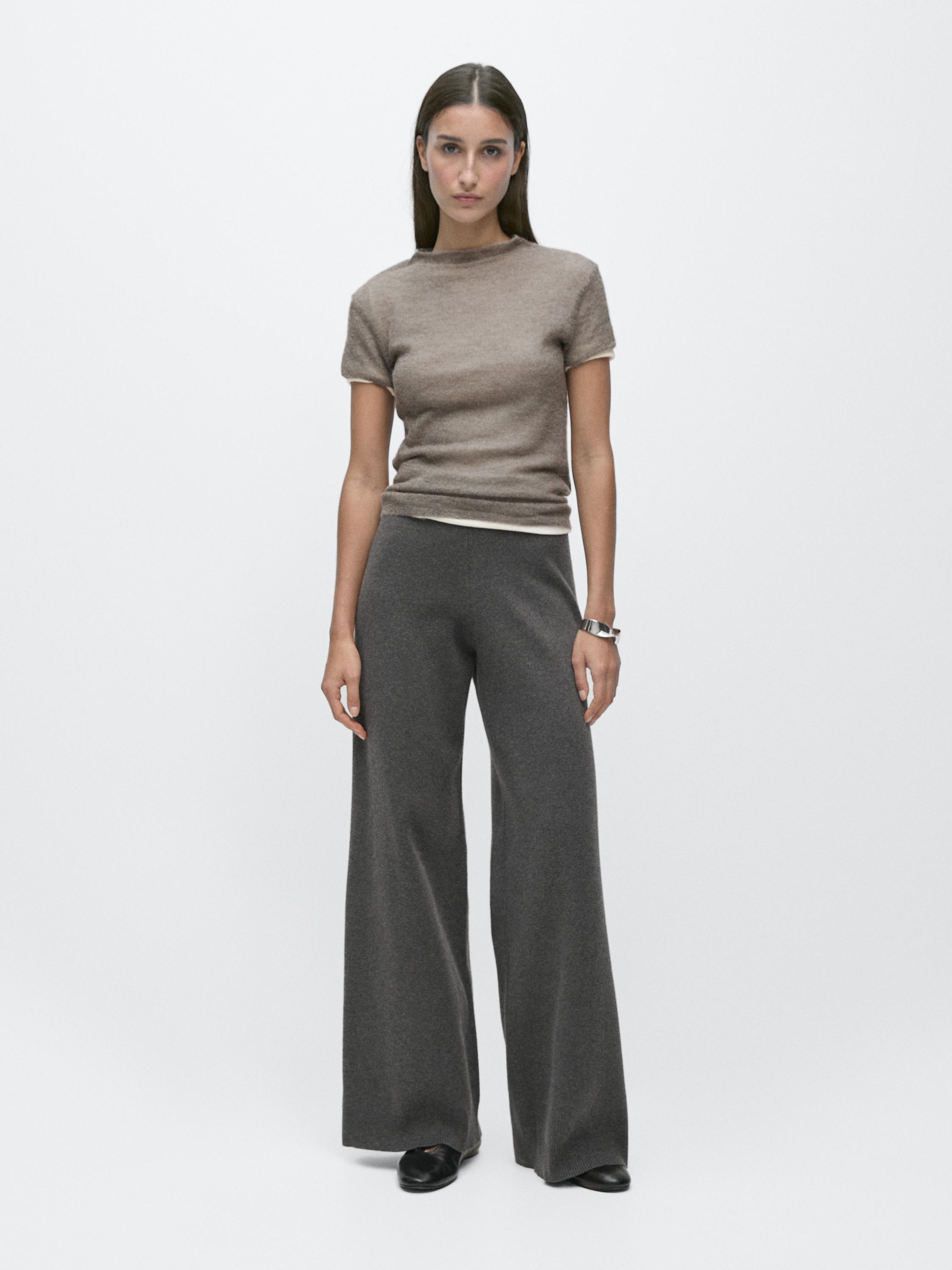 طقم بنطلون رمادي واسع الساقين وتيشيرت بني بأكمام قصيرة.