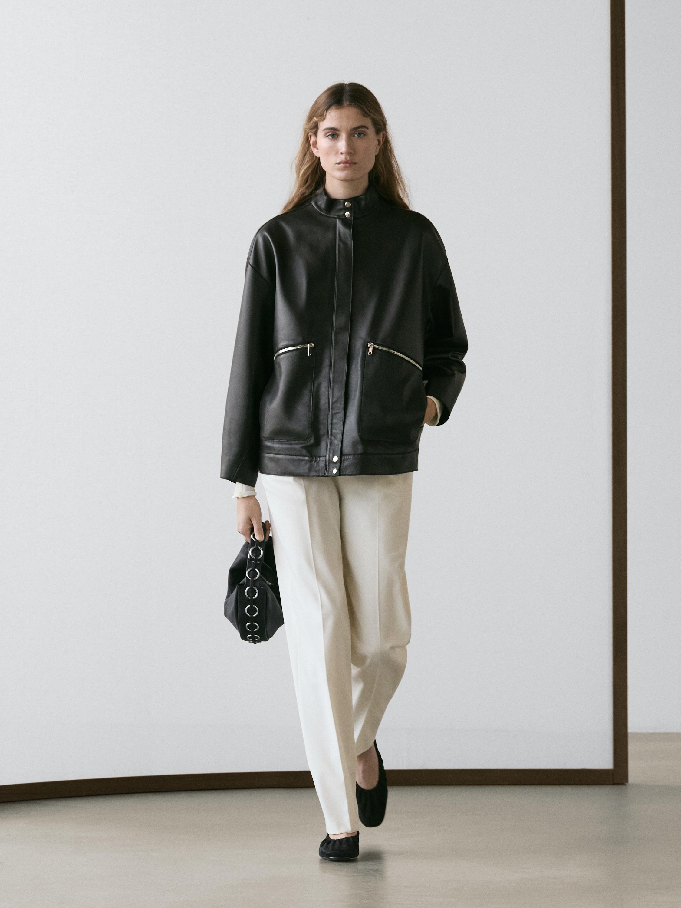 Black jacket set with front pockets and straight white pants.