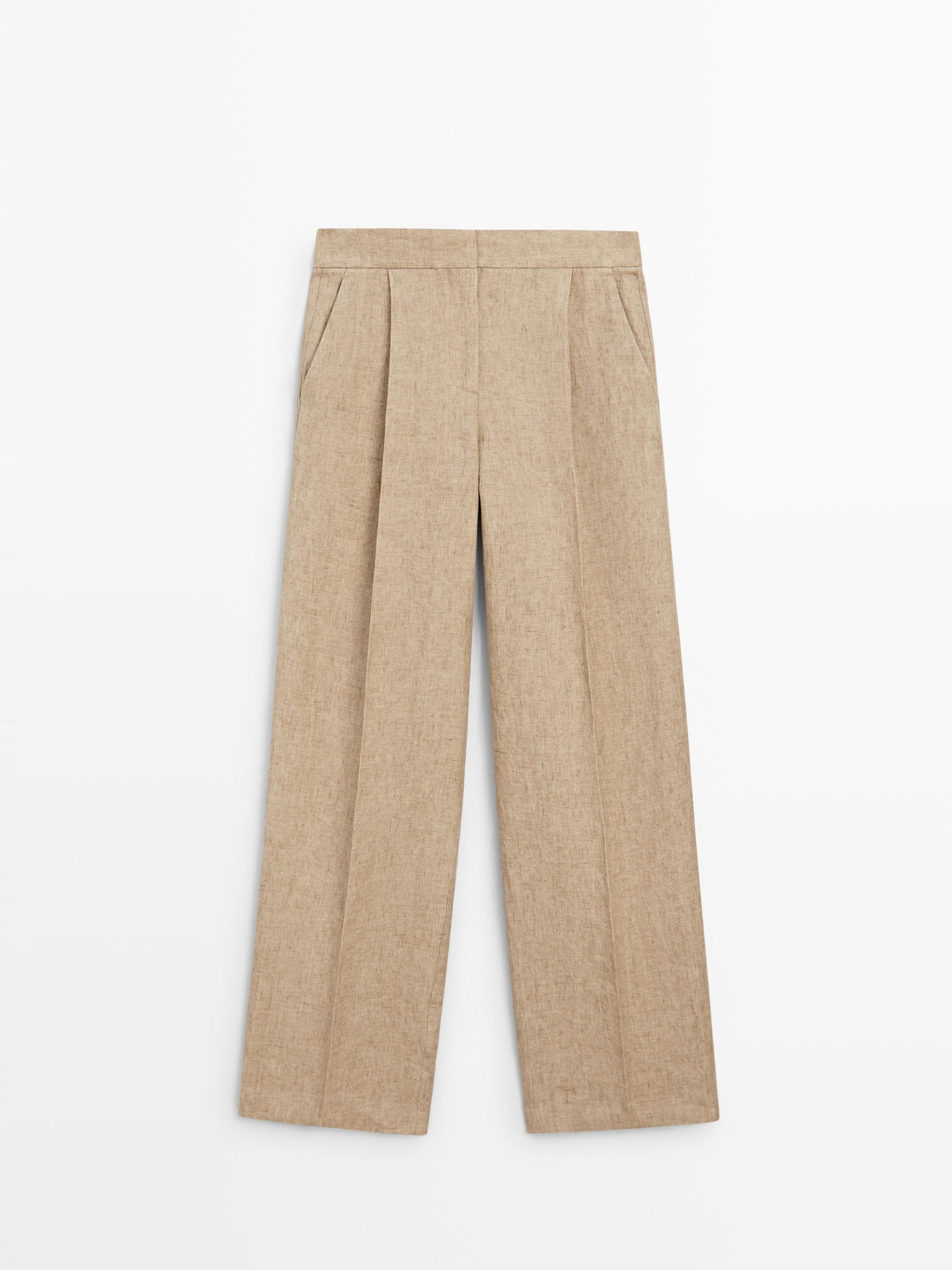 Vue de face d'un pantalon fluide beige avec pinces et poches latérales.