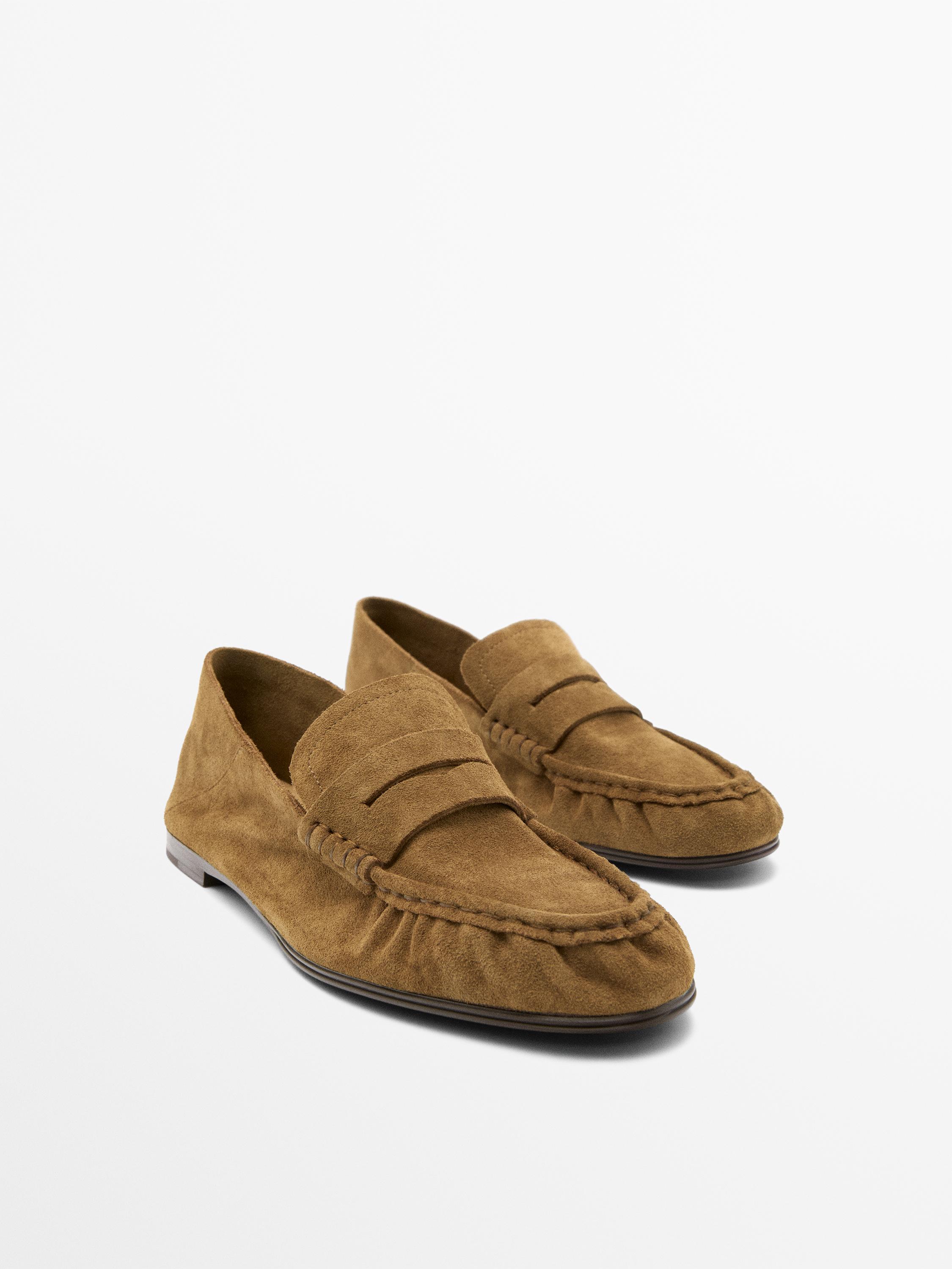 Vorderansicht von camel Moccasins mit sichtbaren Nähten und flacher Sohle.