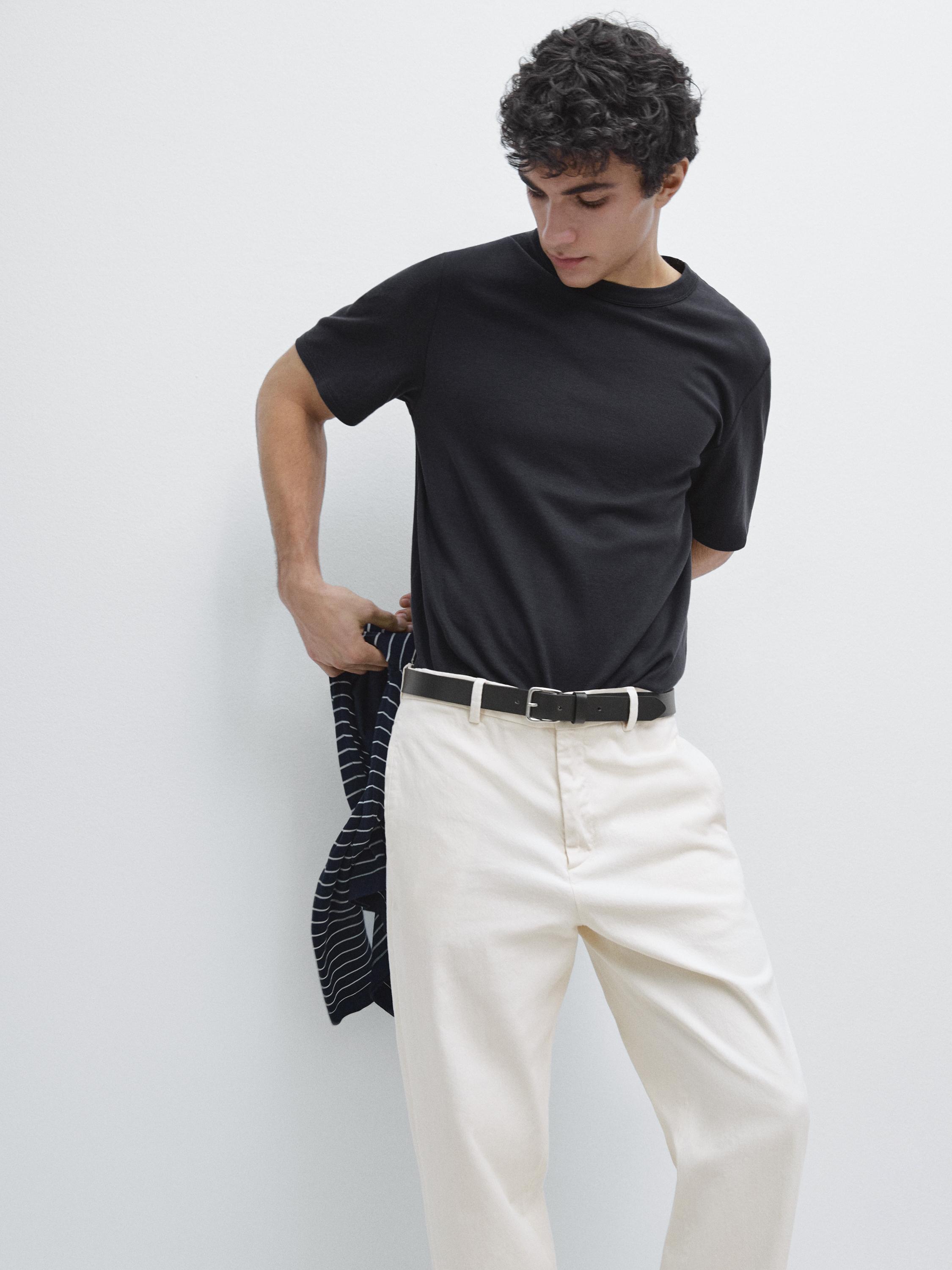 Set bestehend aus einem marineblauen Kurzarm-T-Shirt und einer weißen Hose mit schwarzem Gürtel.