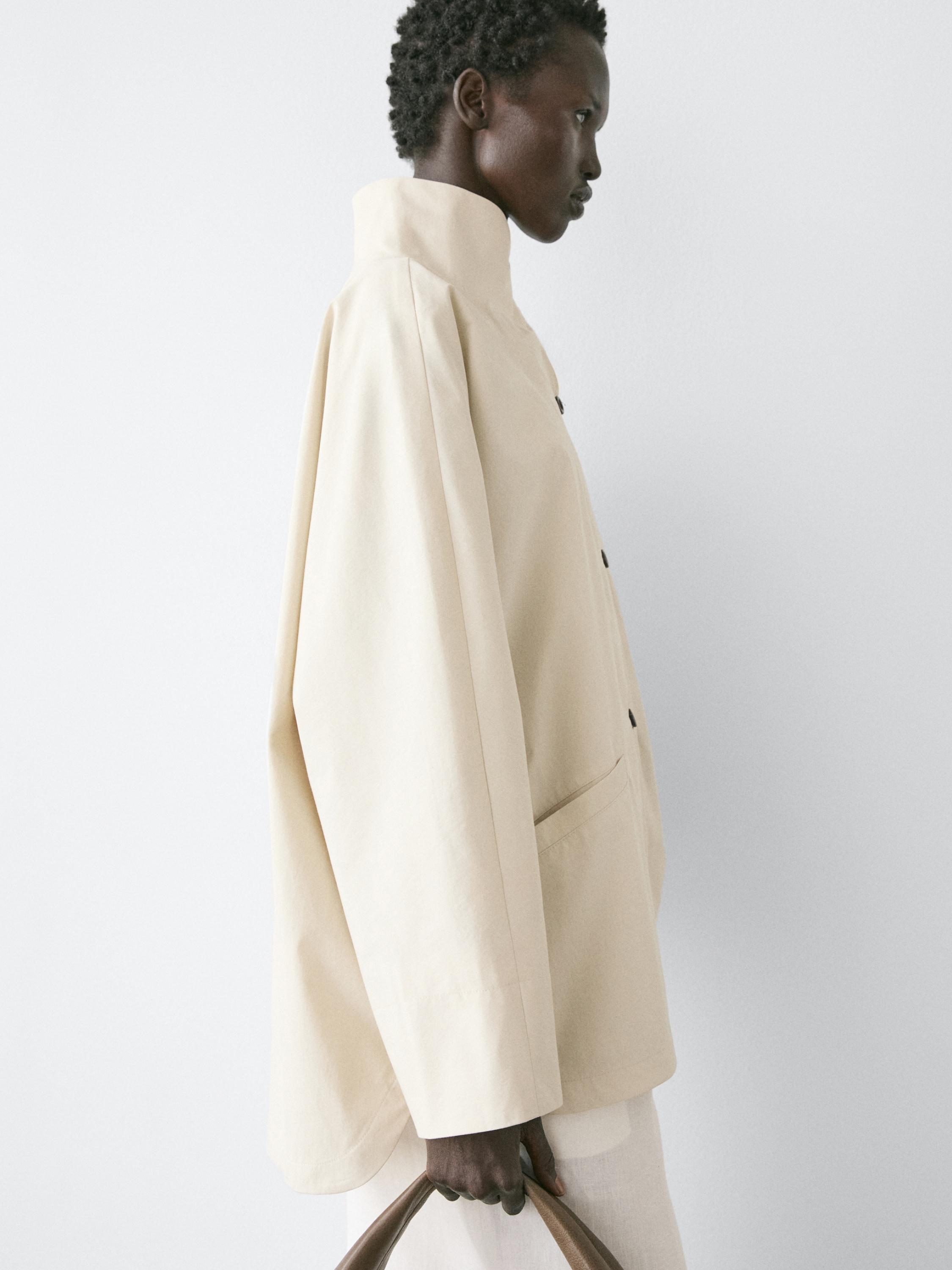 Halbnahe Aufnahme einer roh geschnittenen Jacke mit Stehkragen, durchgehender Knopfleiste und sichtbarer Seitentasche.