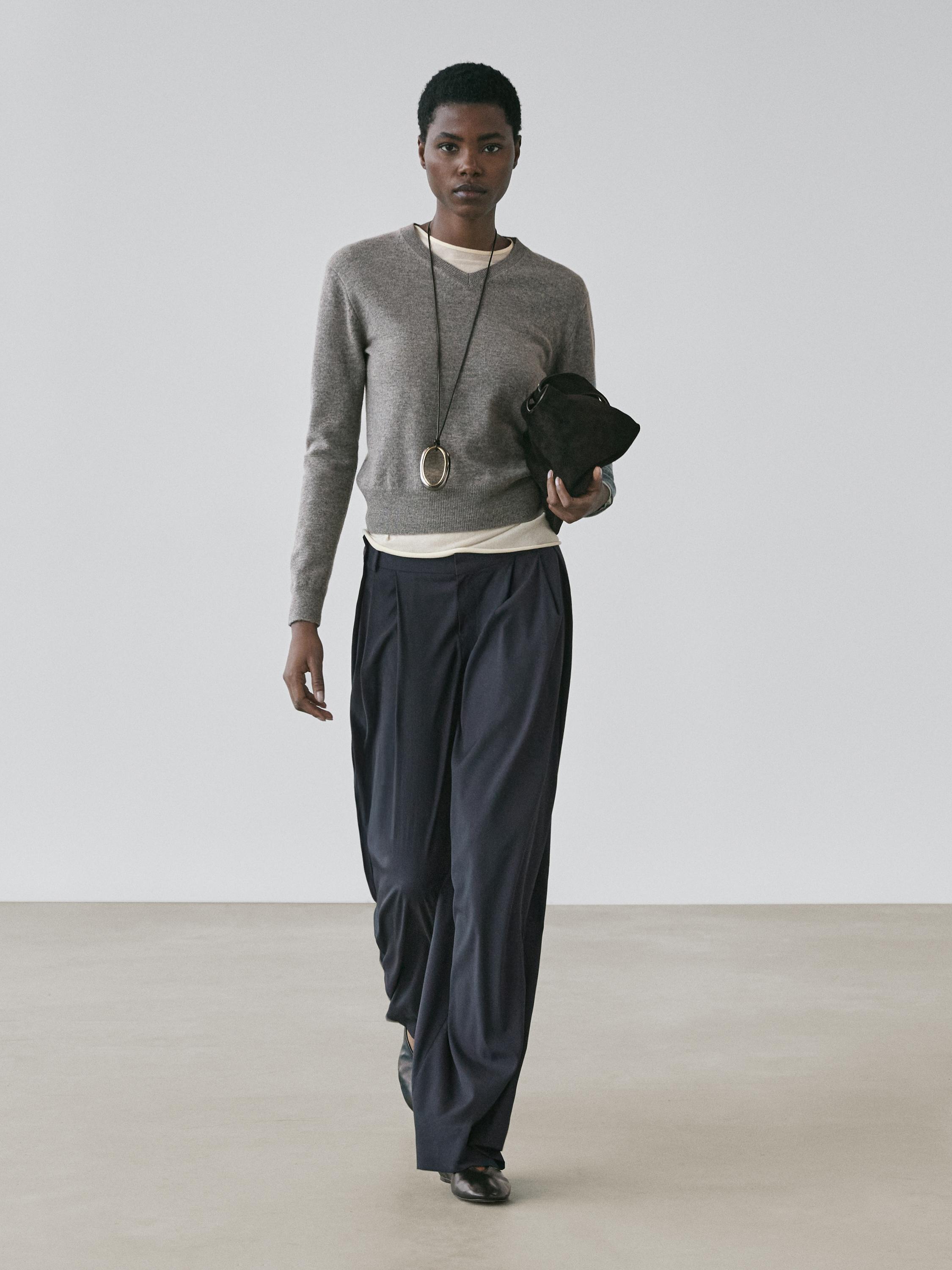 Gray sweater, white t-shirt, and navy blue pleated pants set.