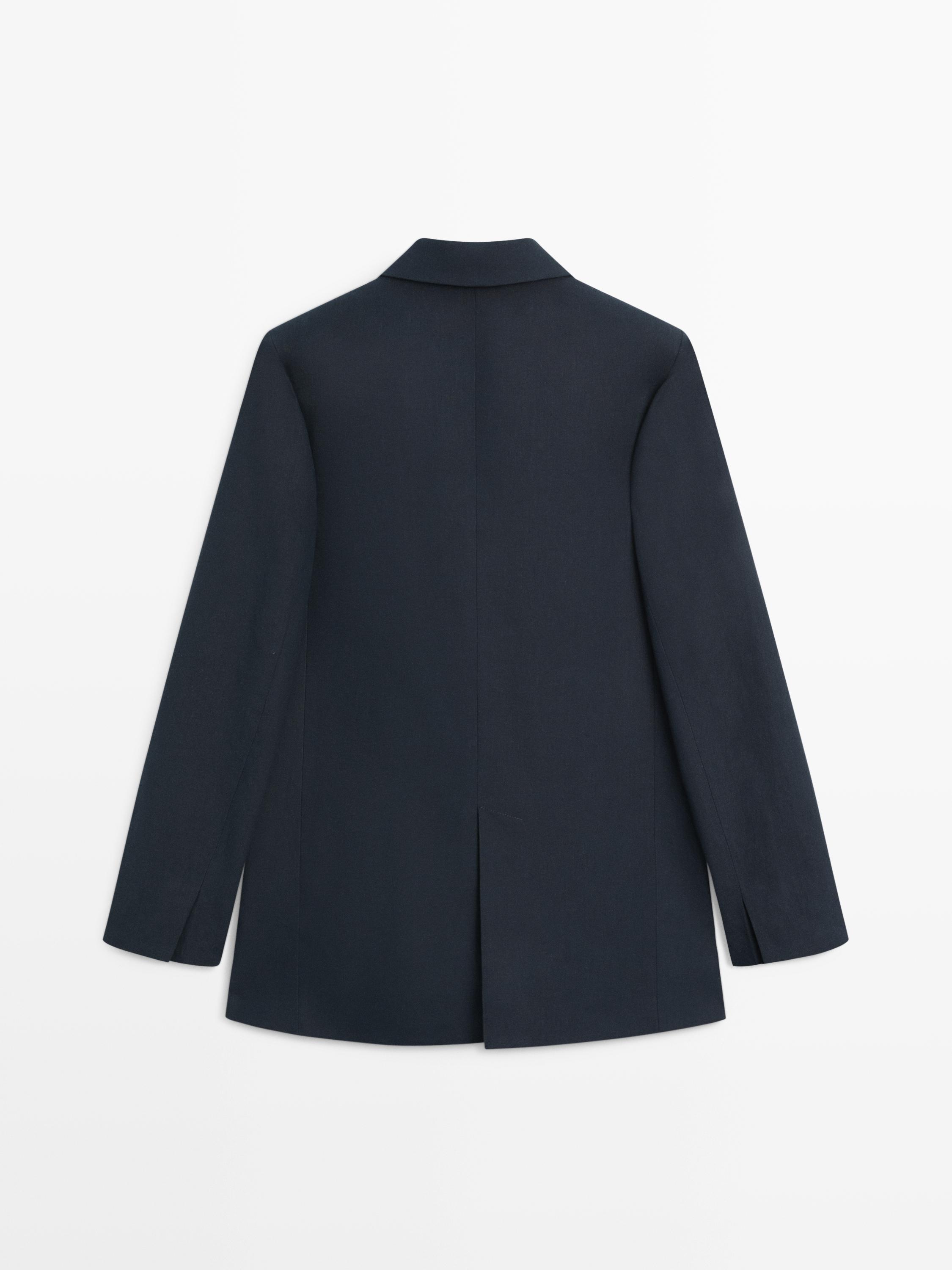 Rear view of navy blue blazer with back vent and long sleeves.