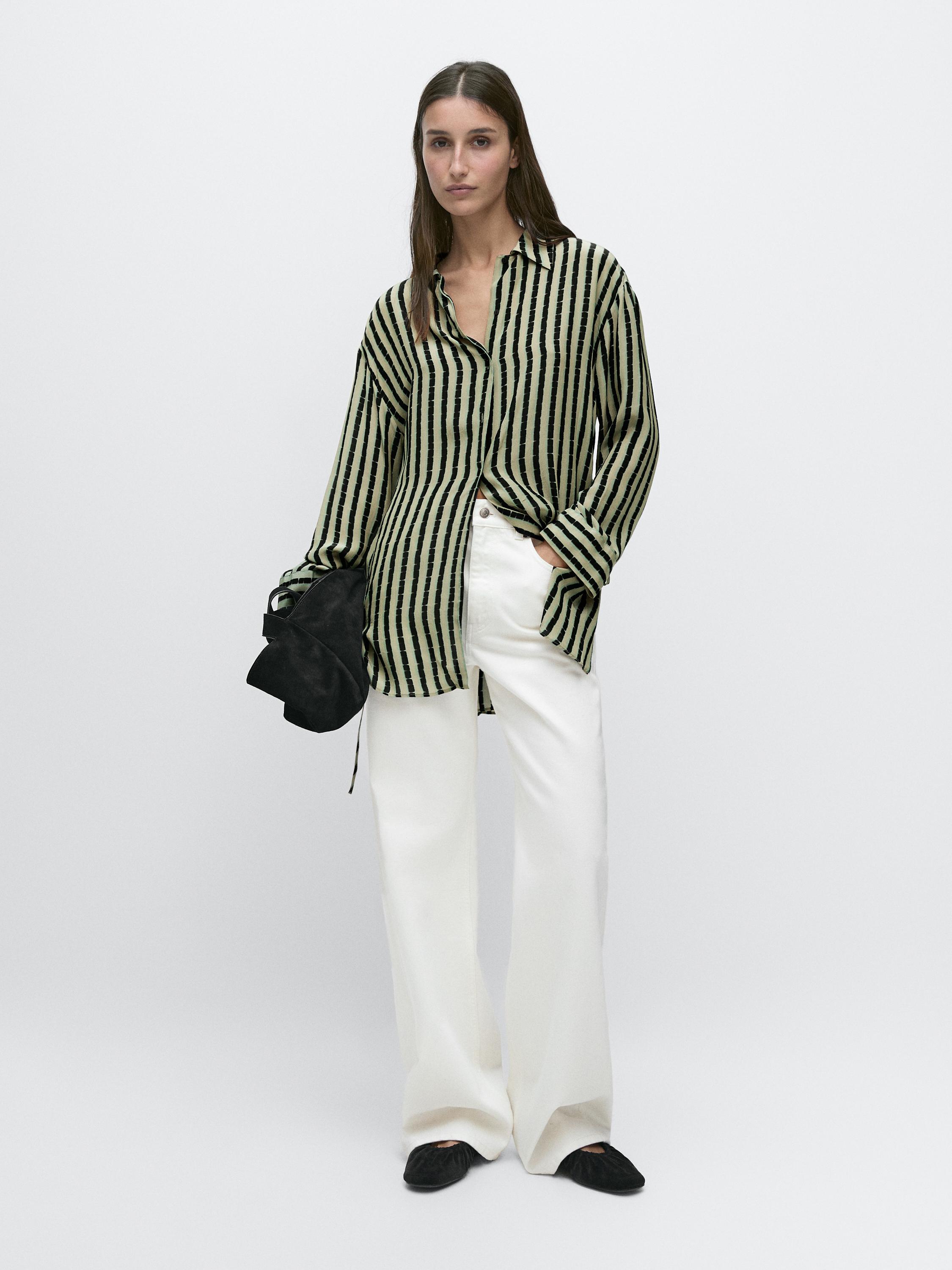 Teal and black striped shirt set with wide-leg white pants and black shoes.