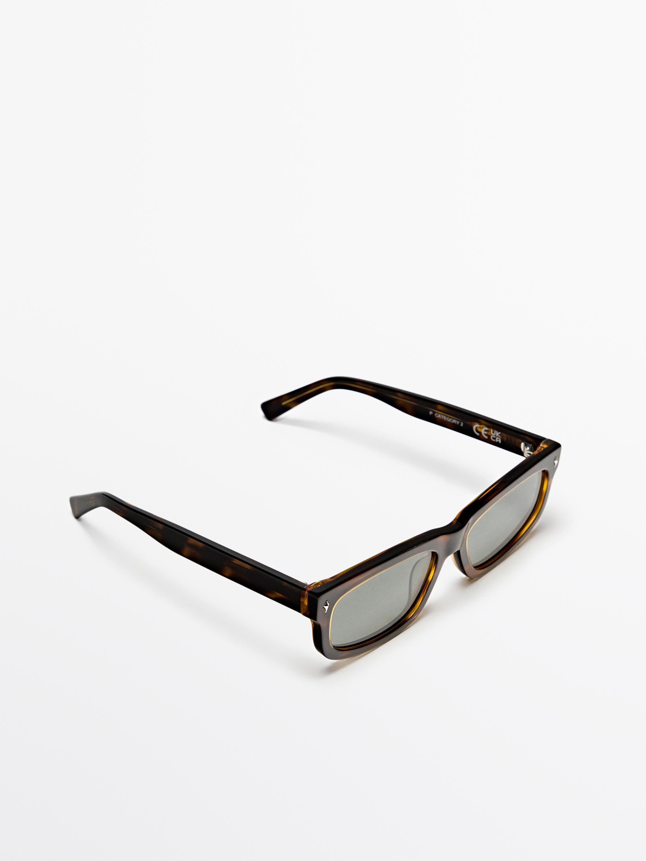 Dikdörtgen çerçeveli ve kaplumbağa kabuğu desenli kahverengi güneş gözlüğü.