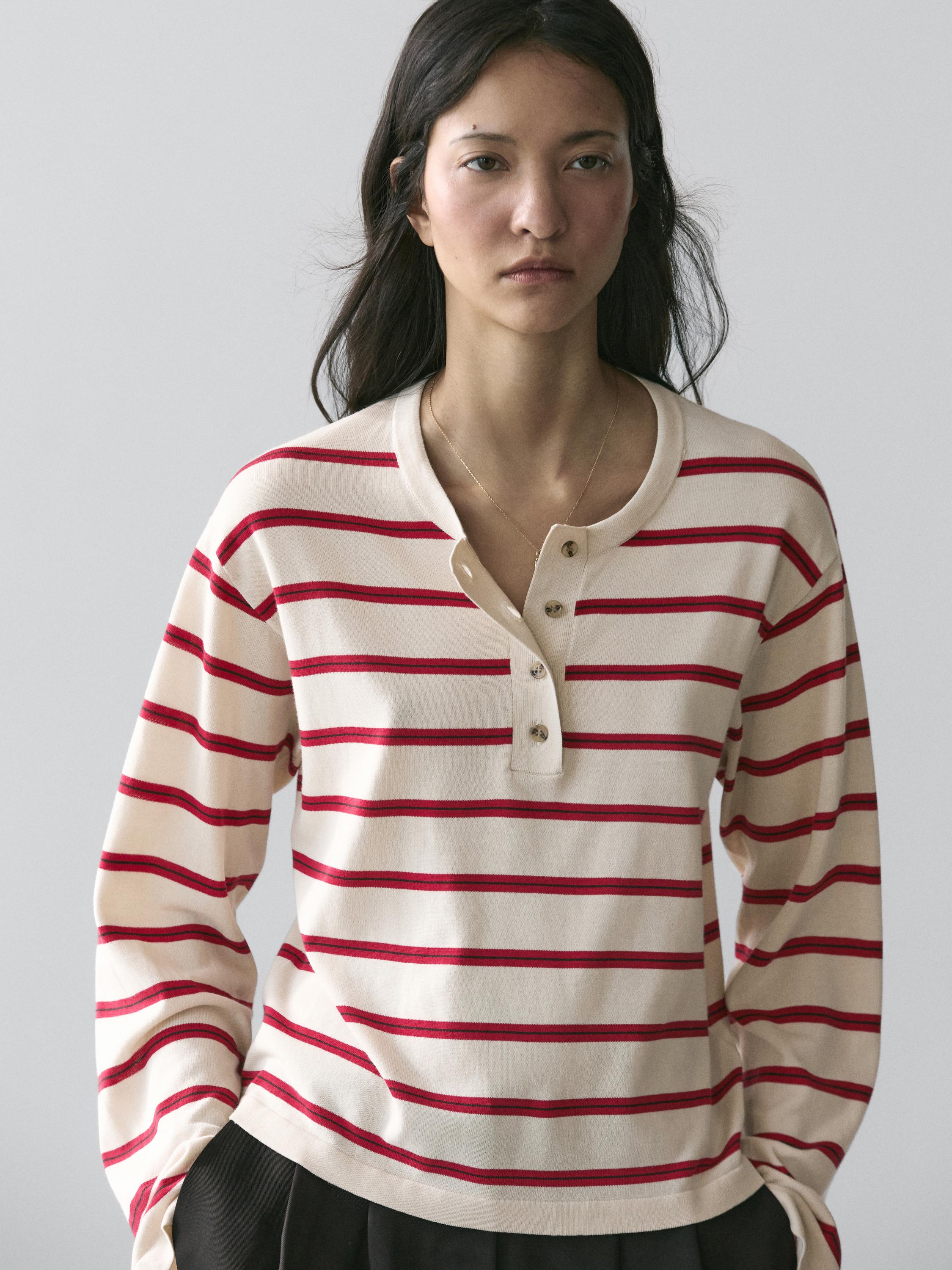 Mid-shot of a red and white striped sweater with a baker collar and front placket.