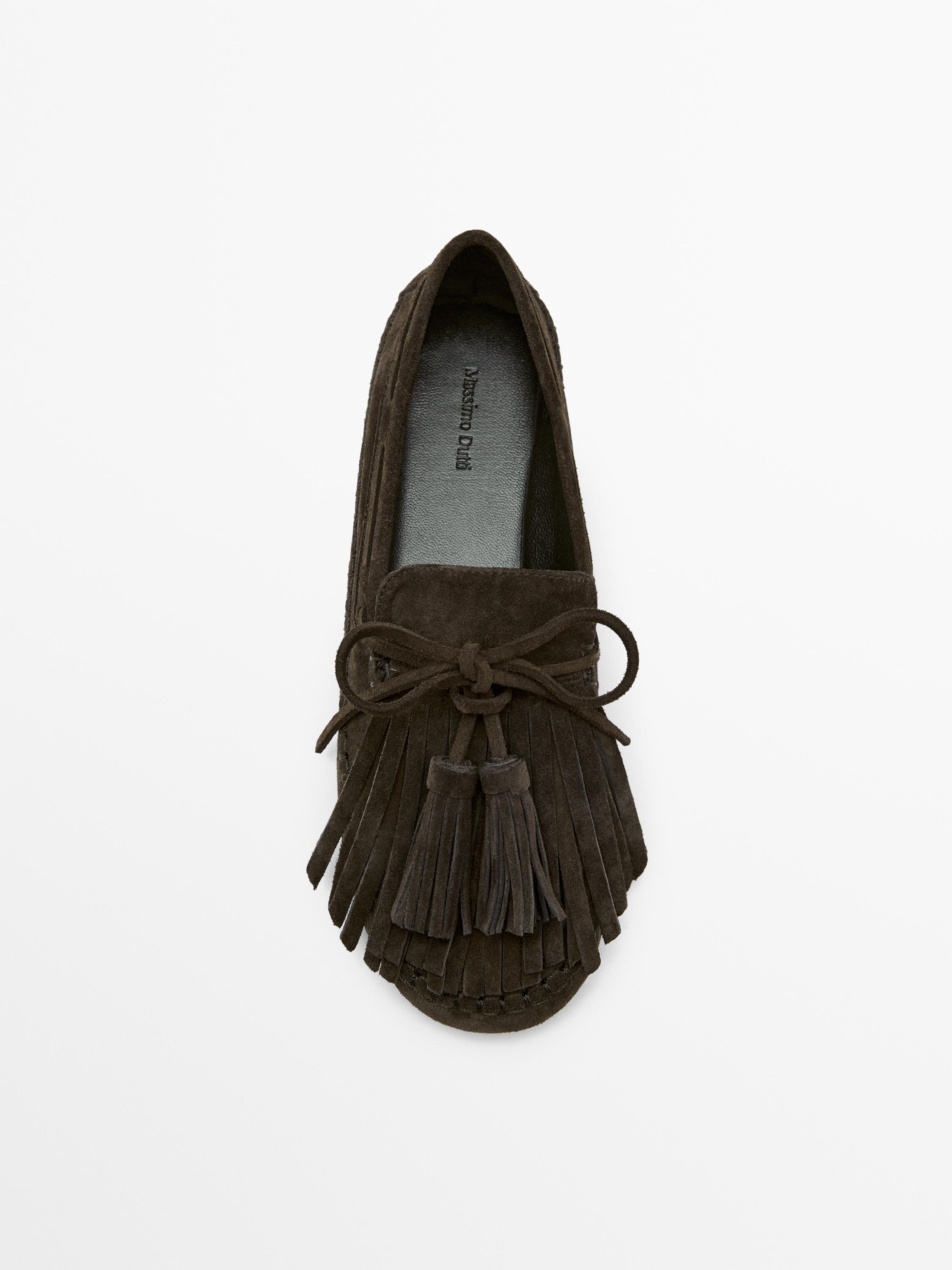 Vue de dessus d'un mocassin marron avec des franges et des pompons à l'avant. Texte visible sur la semelle intérieure: "Massimo Dutti".