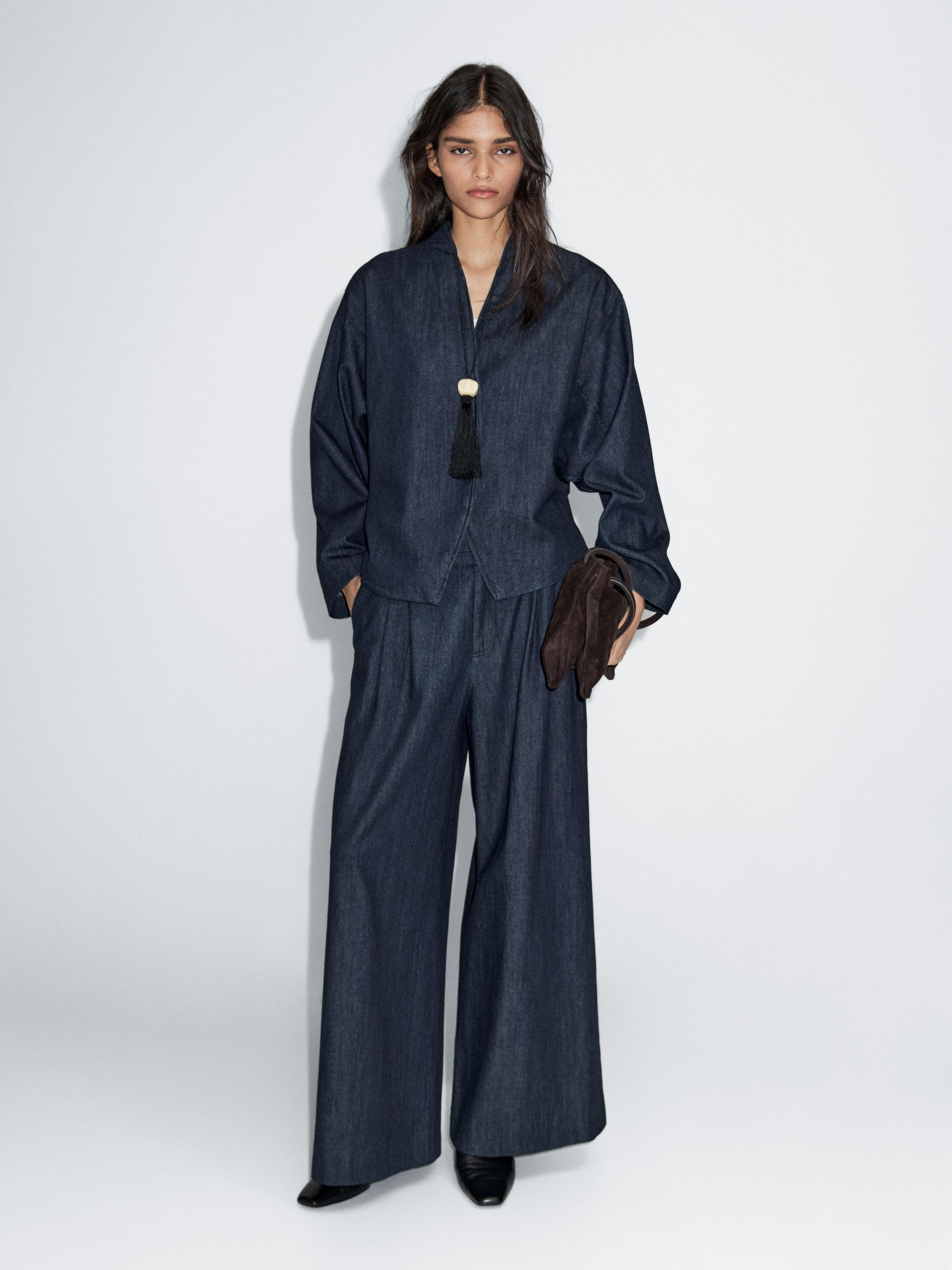 جينز بساق عريضة وتفاصيل بكسرات