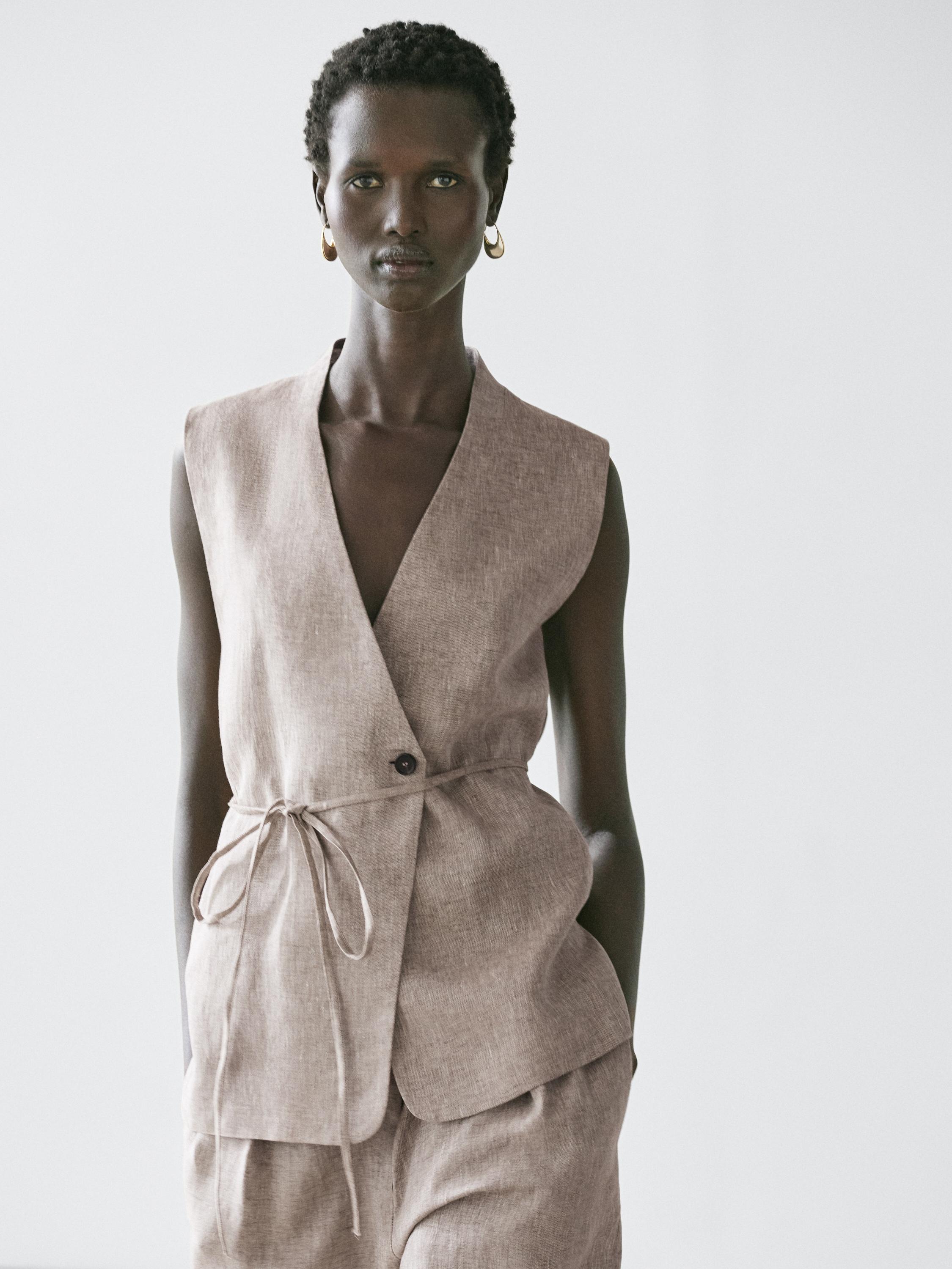 Beige crossover vest and matching pants set with tie.