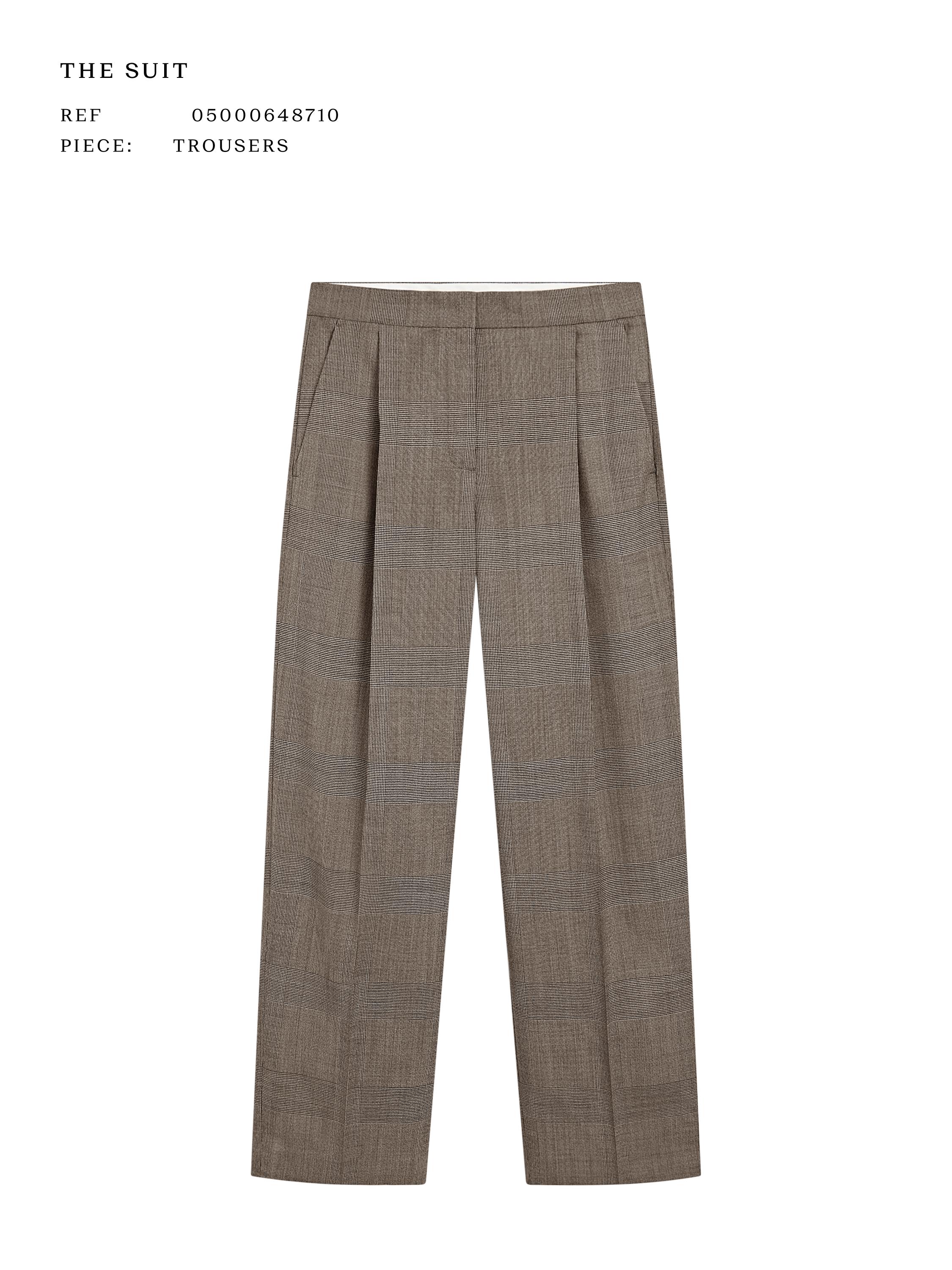 Pamje ballore e pantallonave bezhë me palosje dhe xhepa anësorë. Teksti i dukshëm: "THE SUIT REF 05000648710 PIECE: TROUSERS".