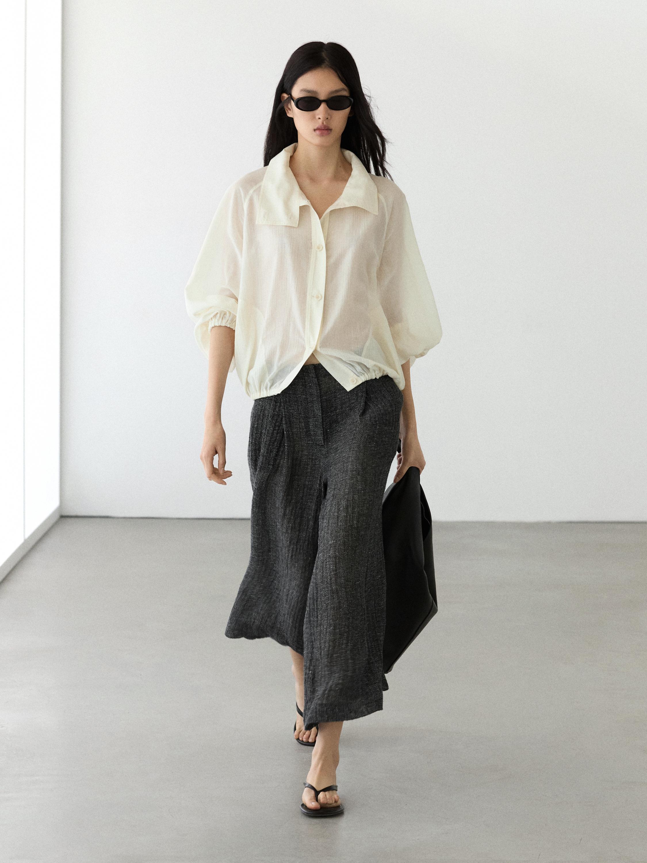 White button-down blouse and wide gray pants set.