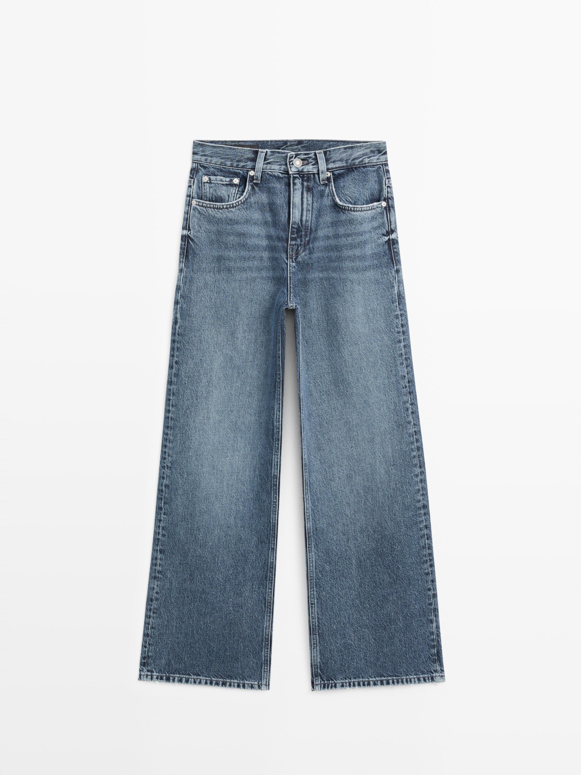 Vue de face d'un jean bleu moyen à jambe large avec poches avant et arrière, fermeture boutonnée et à glissière.