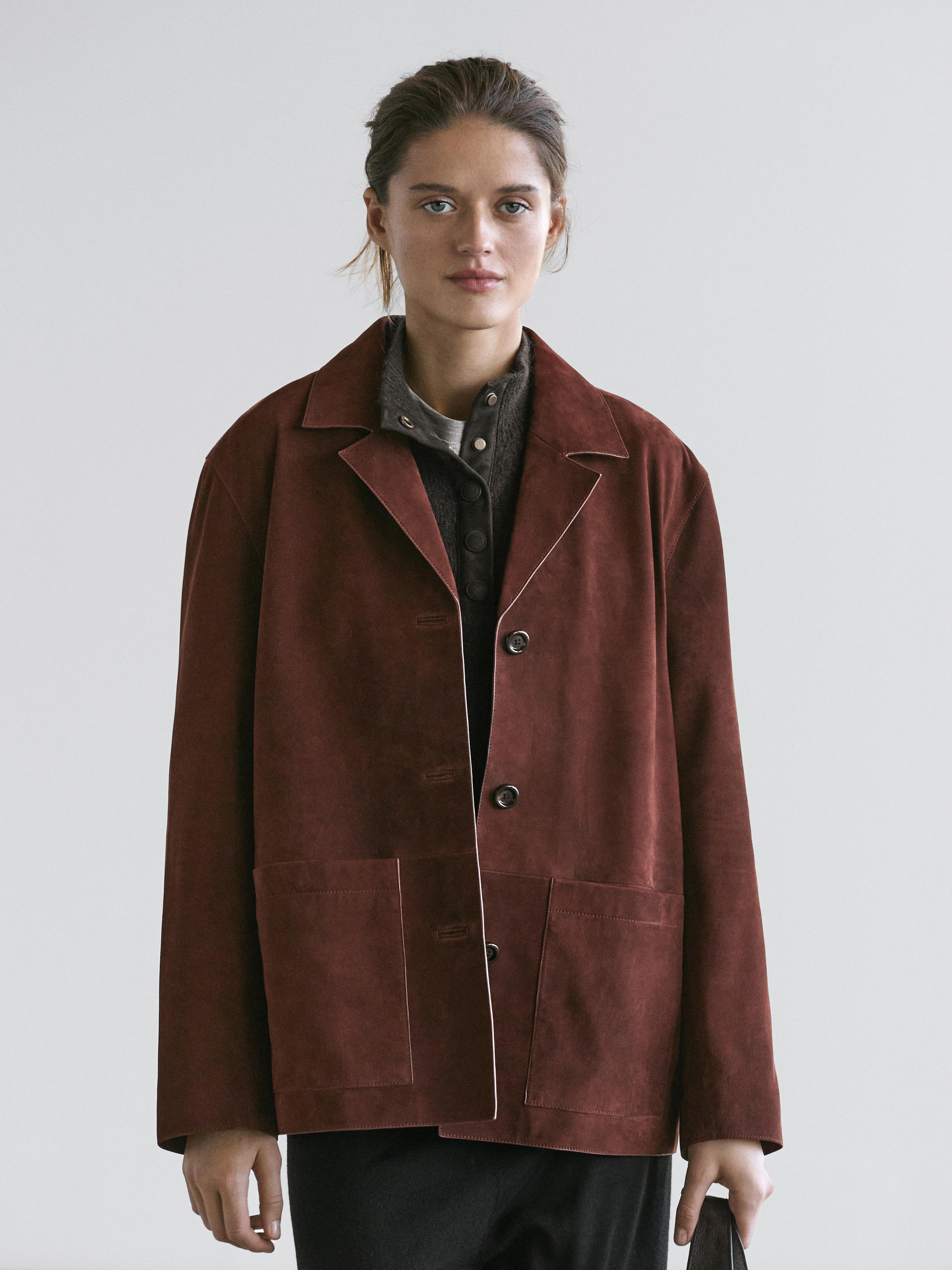 Burgundy jacket set with lapel and large front pockets, over a dark shirt with visible buttons.