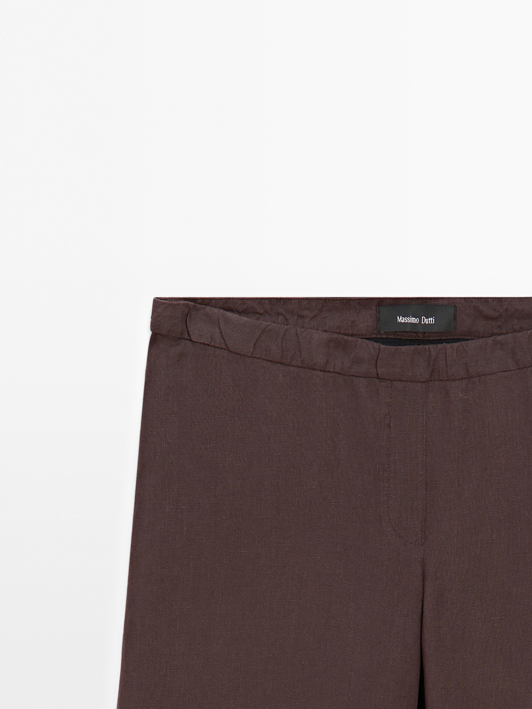 تفاصيل حزام بنطلون بني مع وجود علامة بارزة.