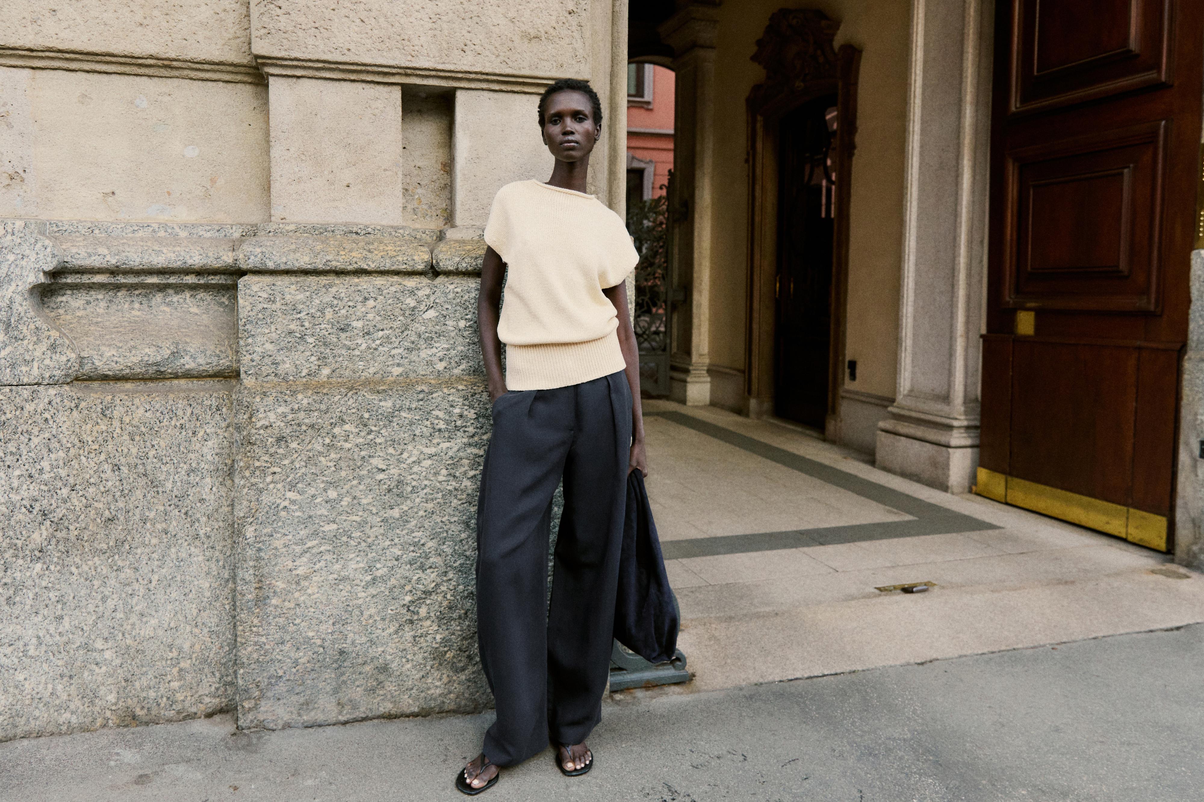 Σετ μπεζ κοντομάνικη μπλούζα και μαύρο παντελόνι φαρδιάς γραμμής.