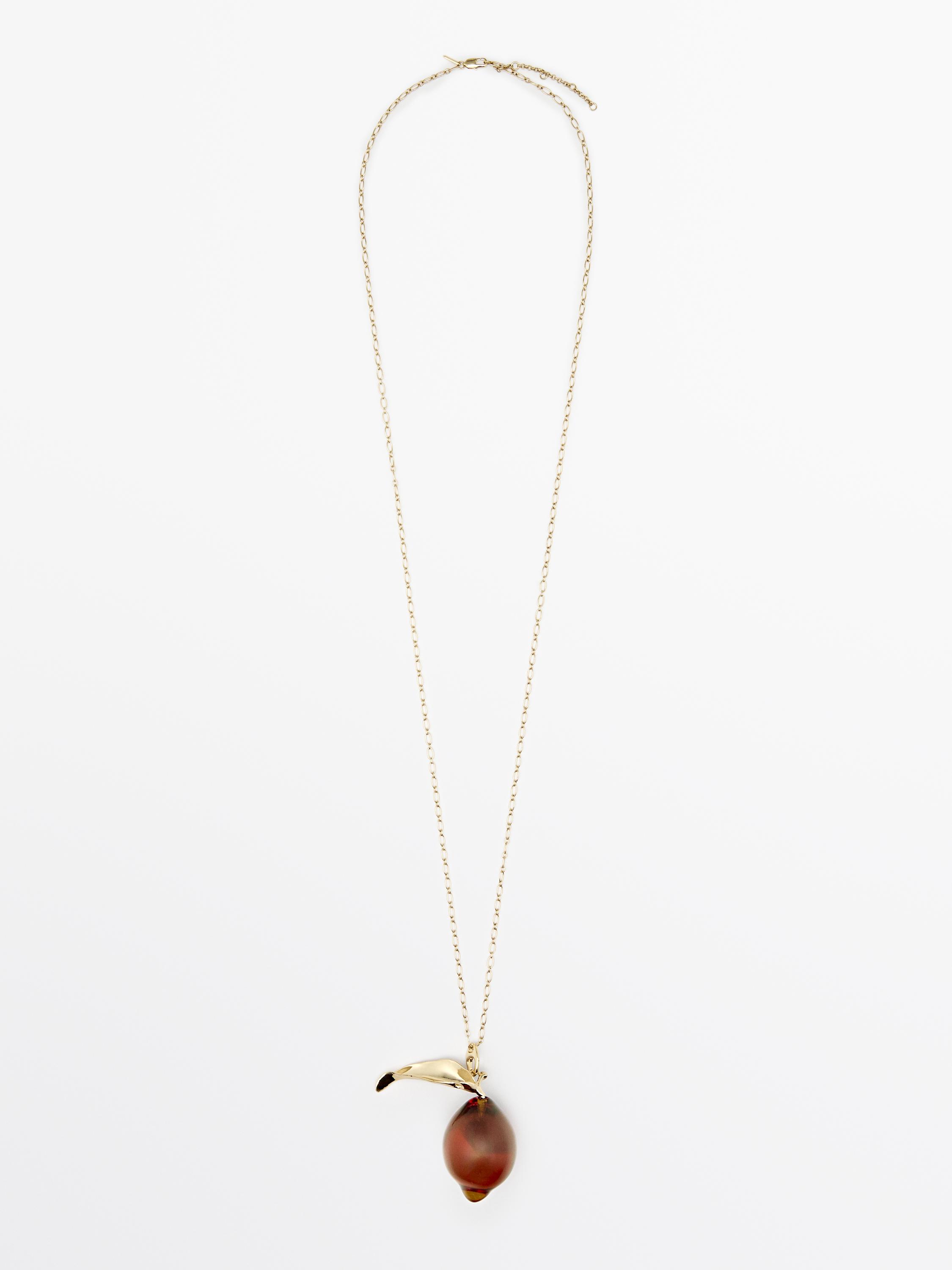 Goldene Halskette mit feiner Kette und braunem Glasanhänger mit geschwungenem Metalldetail.