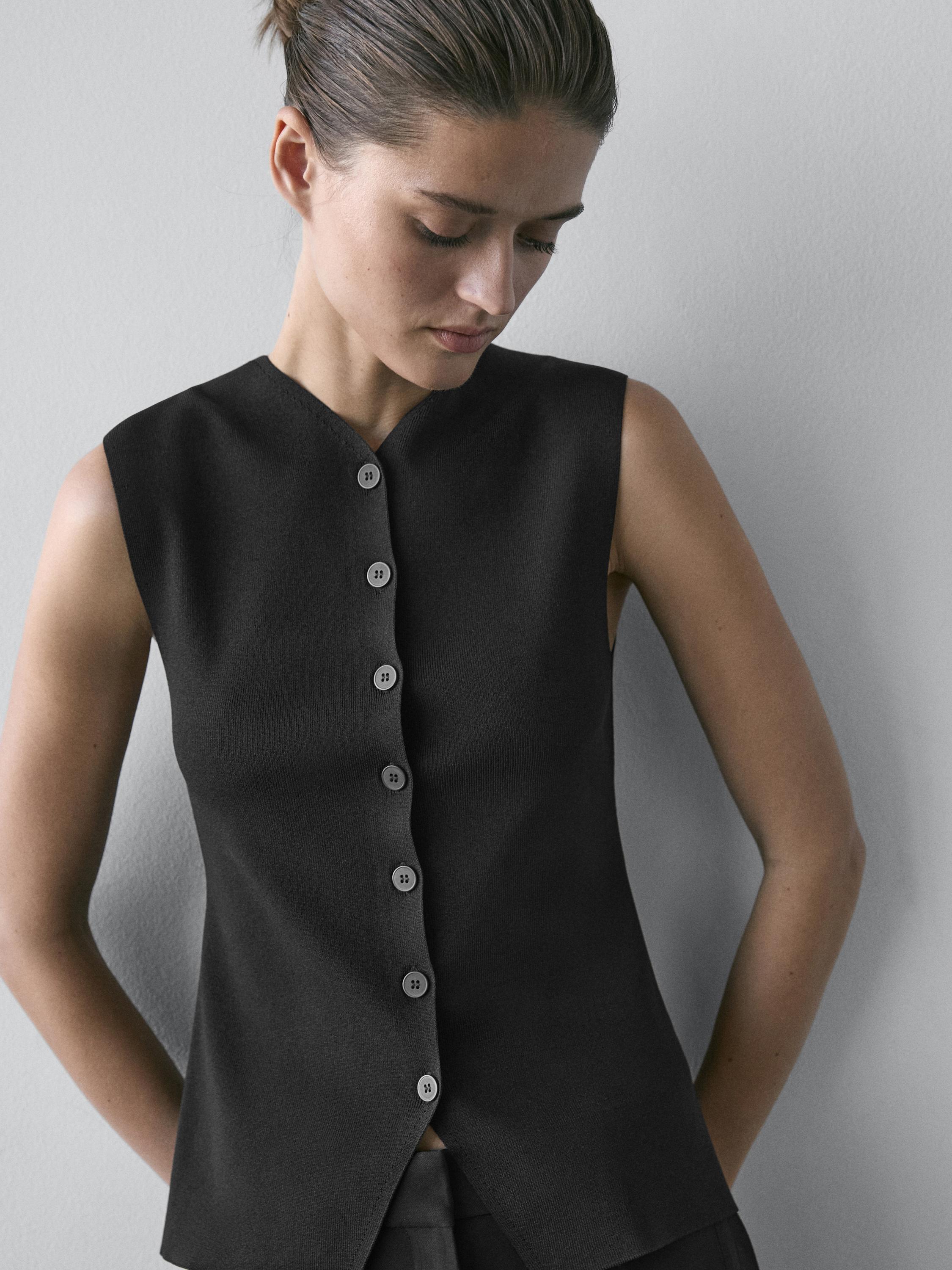 Medium shot of a black vest with a V-neck and front buttons.