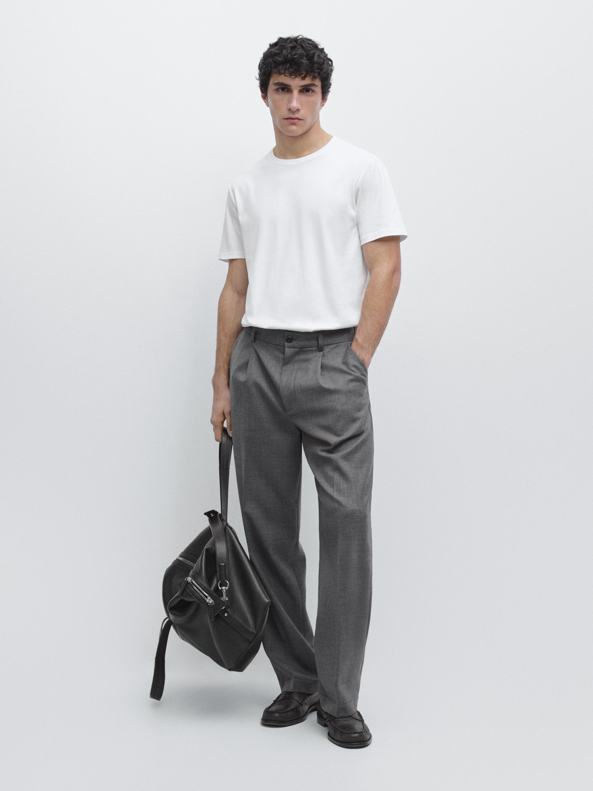 Conjunto de t-shirt branca de manga curta e calças cinzentas com bolsos laterais.