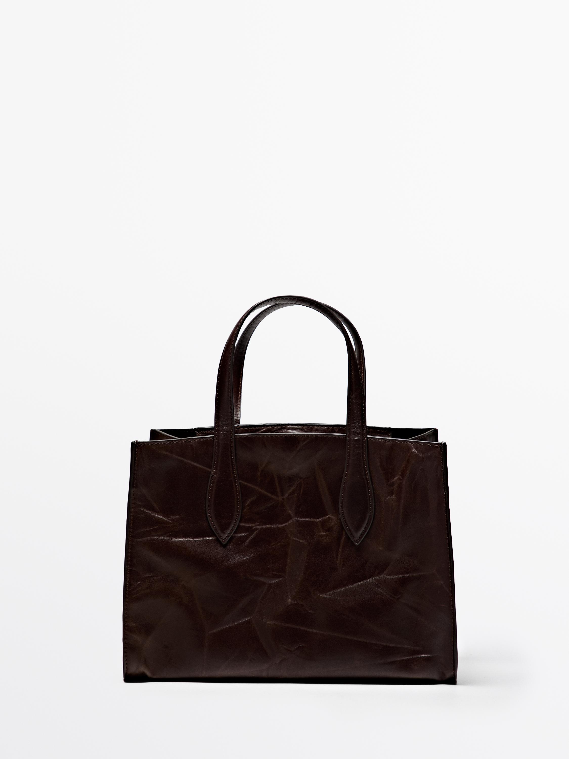 Vista frontal de bolso marrón con asas dobres e deseño estruturado. Dimensións: 20 x 28 x 17 cm.