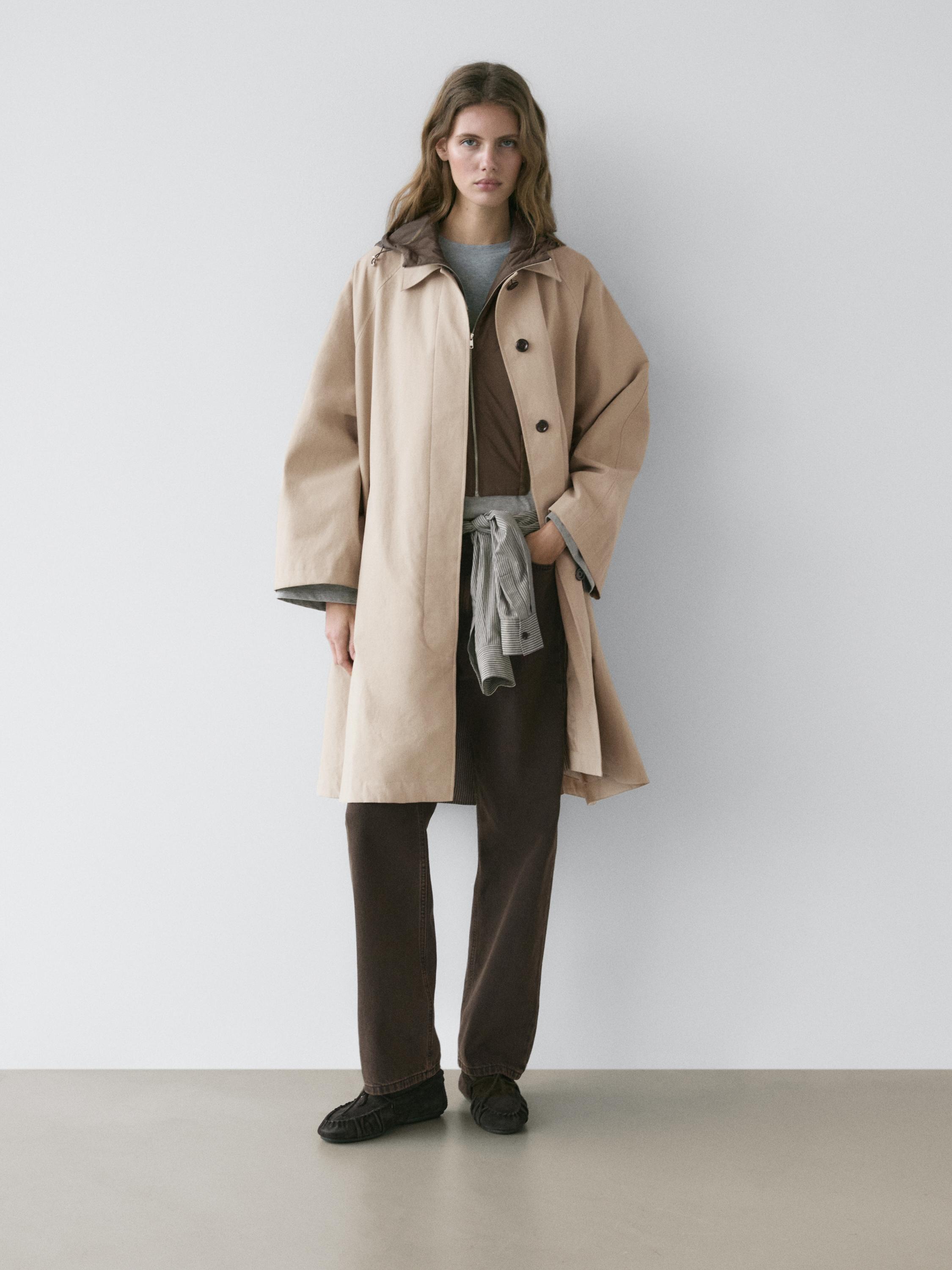 طقم ترنش بيج مع قبعة، بنطلون بني وتي شيرت رمادي.