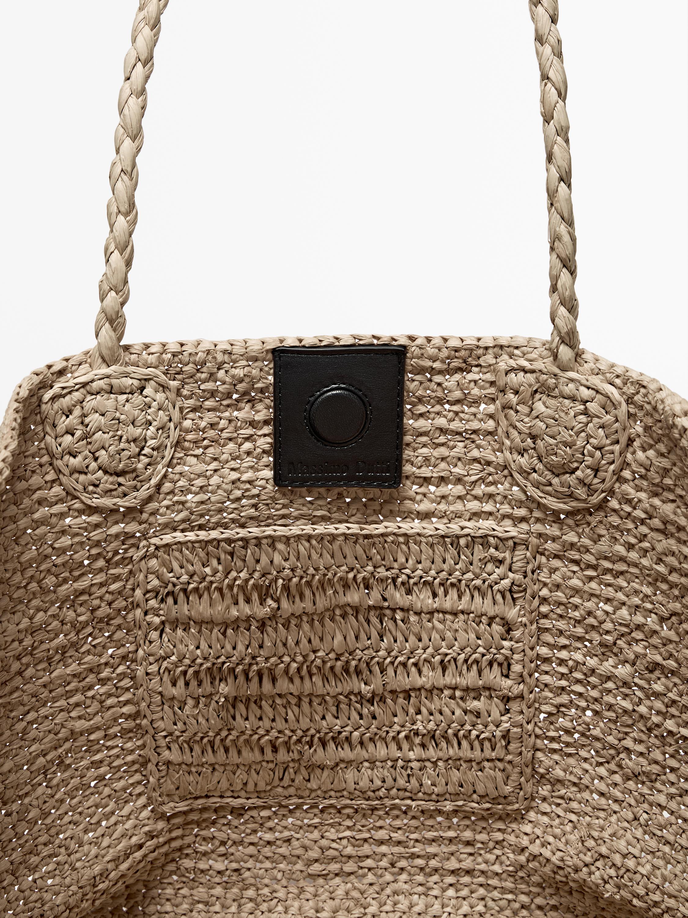 Woven bag detail with braided handles and black button closure