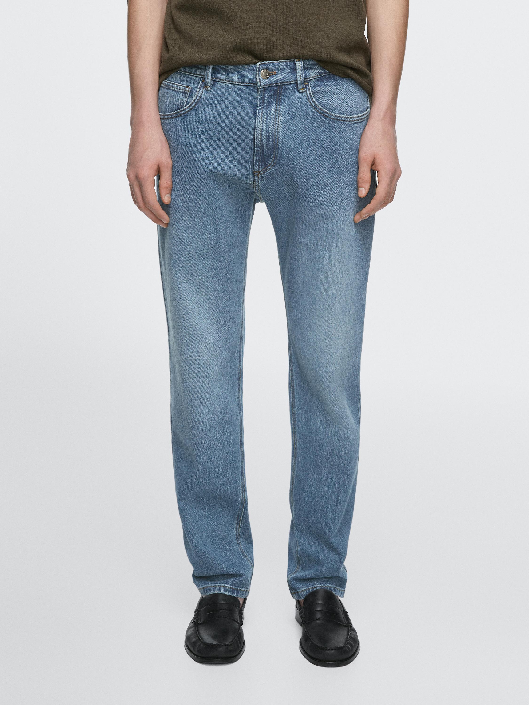 "لقطة متوسطة لبنطلون جينز أزرق بجيوب أمامية وخلفية، وزر وسحاب للإغلاق."