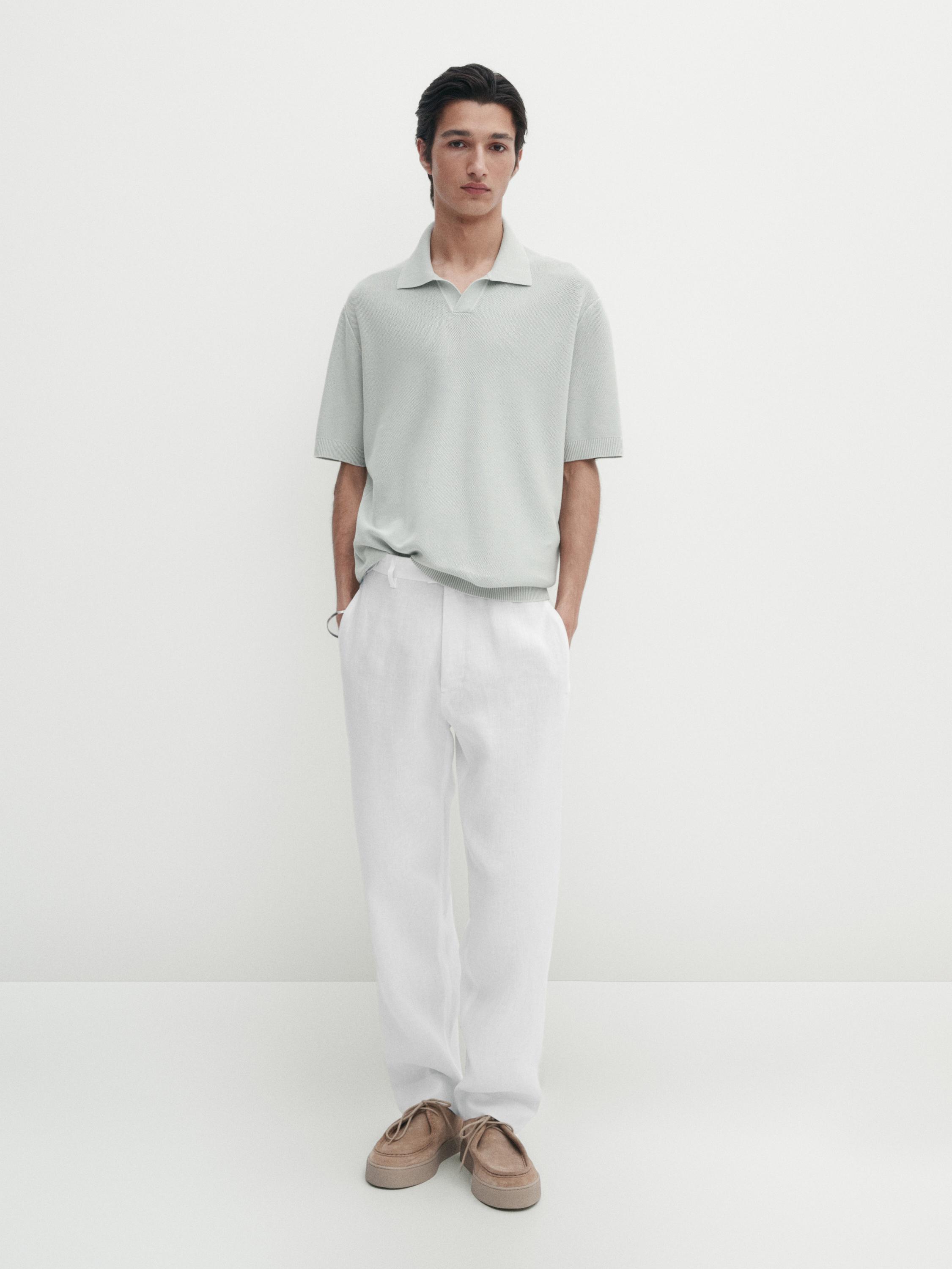 Ensemble composé d'un polo gris clair et d'un pantalon blanc avec des chaussures marron