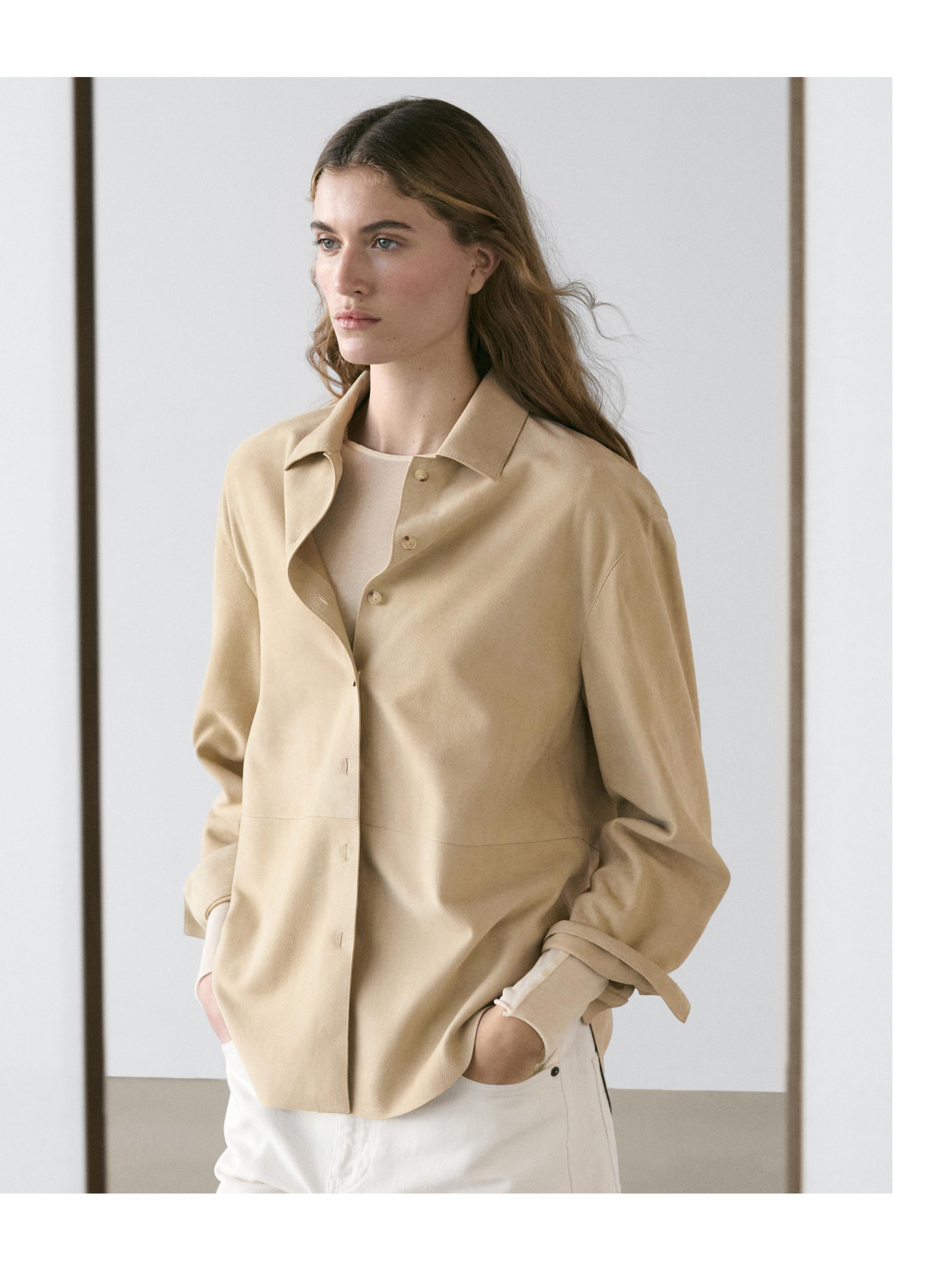 Liivakarva särgi keskmine plaan esinööbitava ja klassikalise kraega, kombineeritud valgete pükstega.