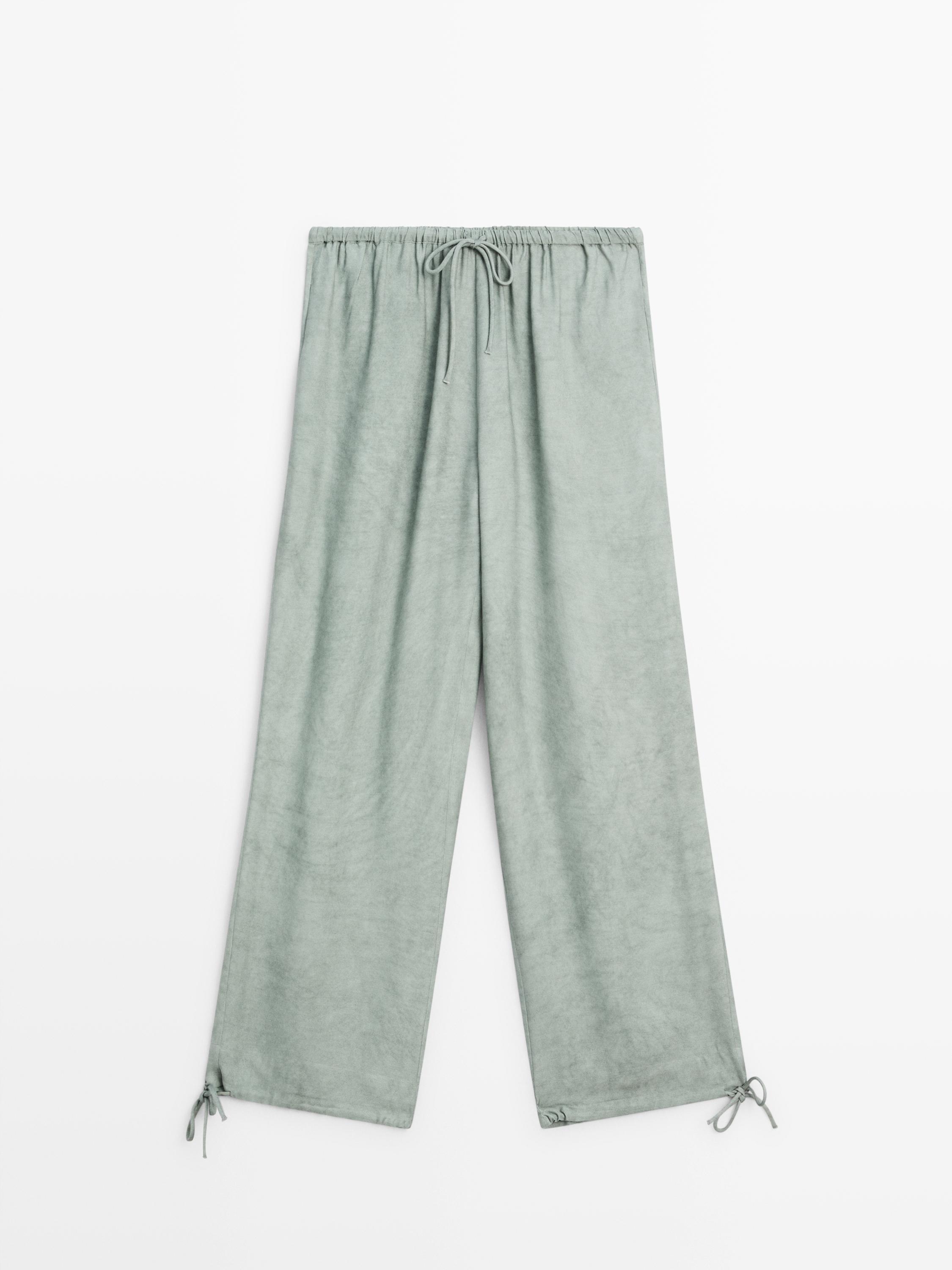กางเกงขายาวสีพิสตาชิโอ ด้านหน้าเป็นยางยืดที่เอวและมีเชือกปรับได้ที่ชายเสื้อ