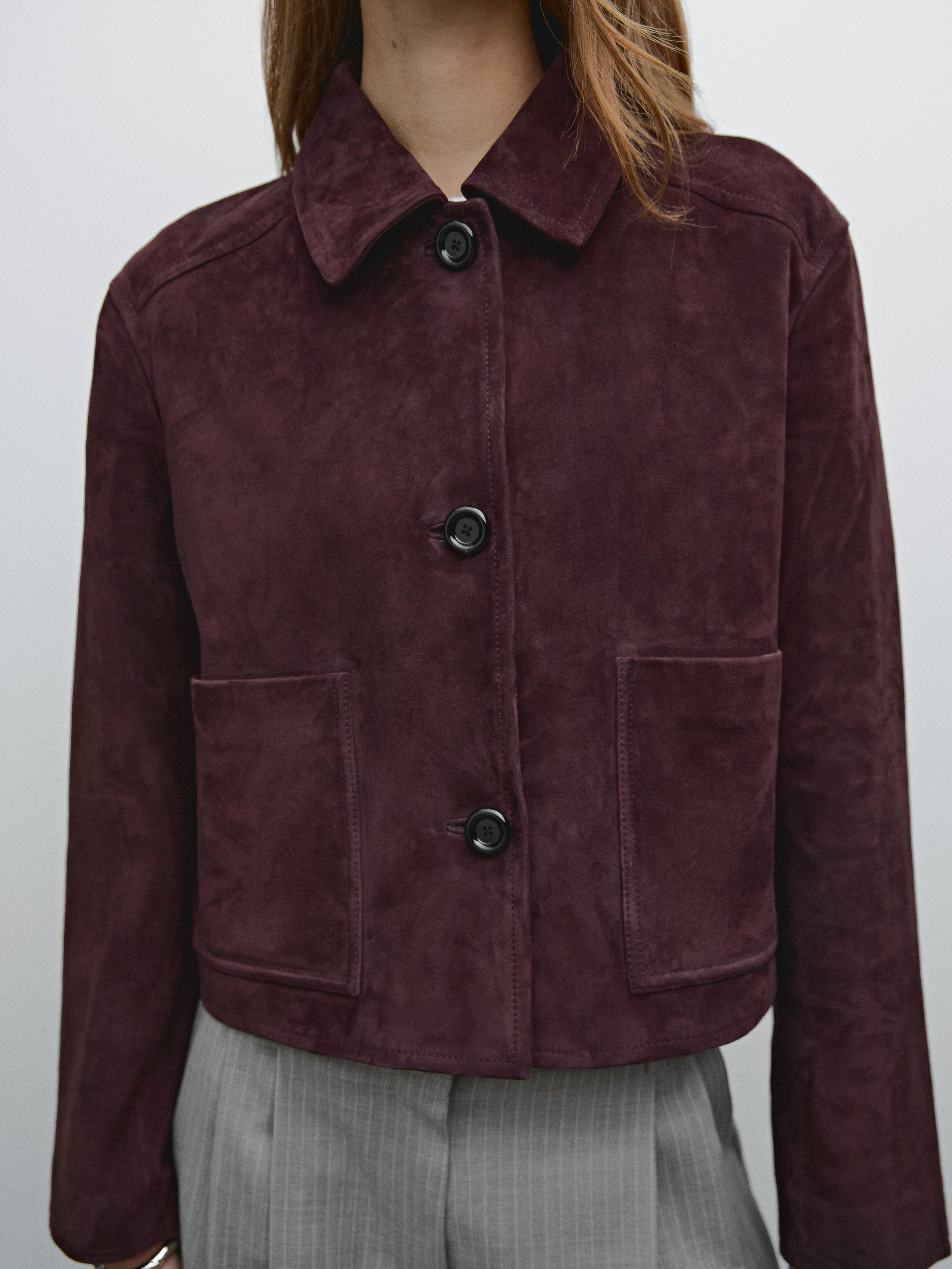 Plan moyen d'une veste bordeaux avec boutons sur le devant et grandes poches