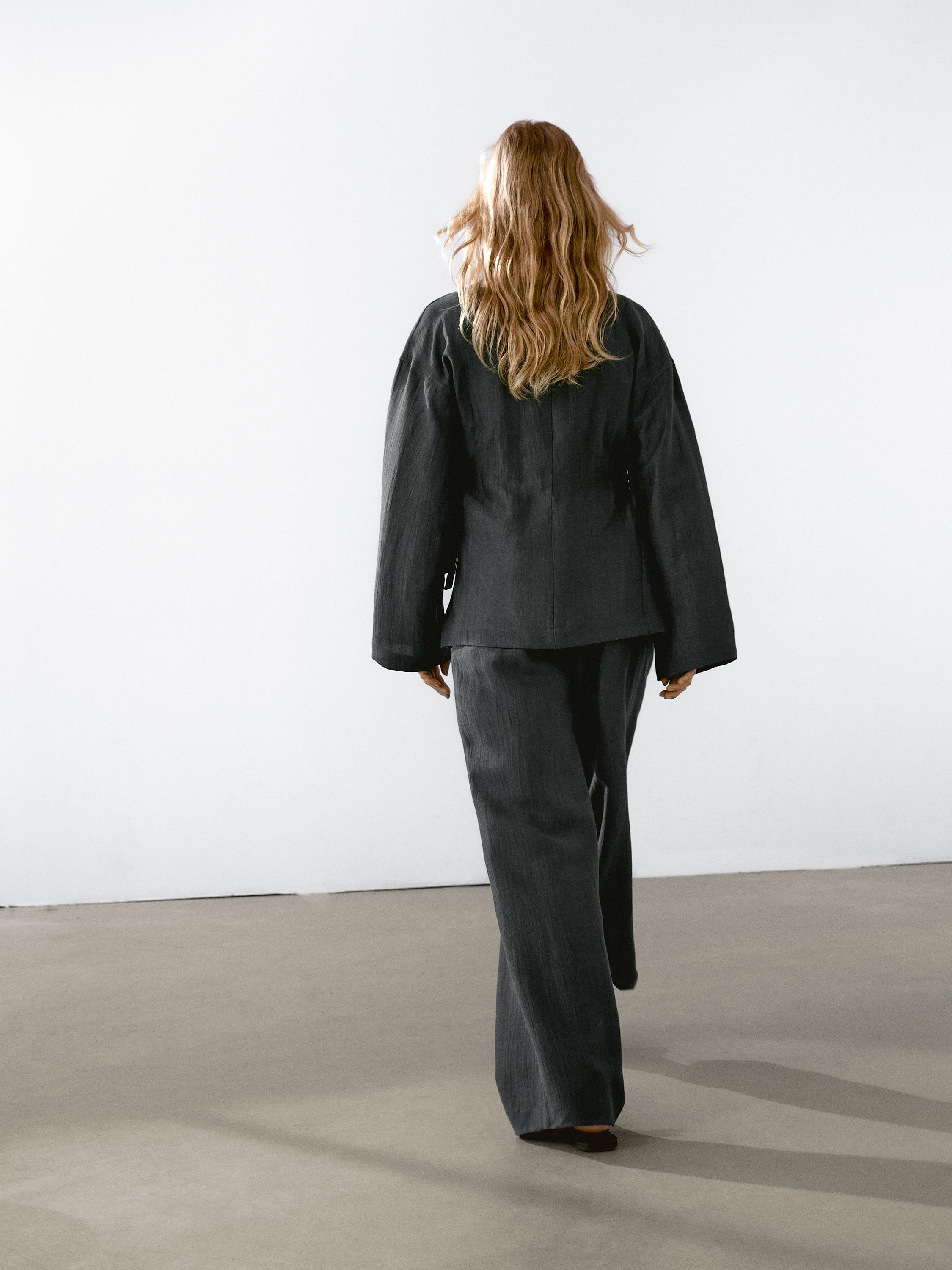 Conjunto de chaqueta y pantalón negro con vista posterior