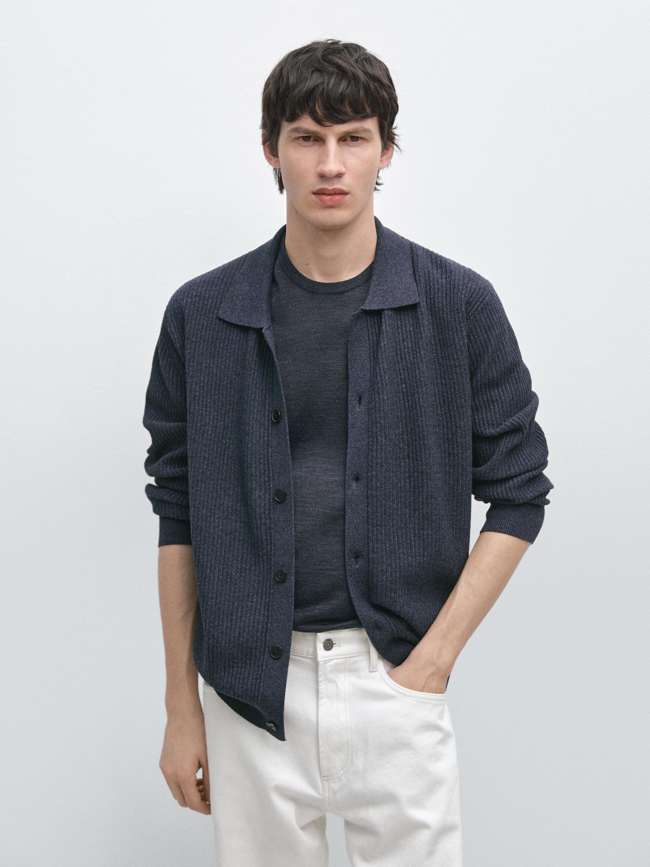 Conjunto de cárdigan indigo de punto canalé con botones y camiseta a juego, pantalones blancos con bolsillos laterales.