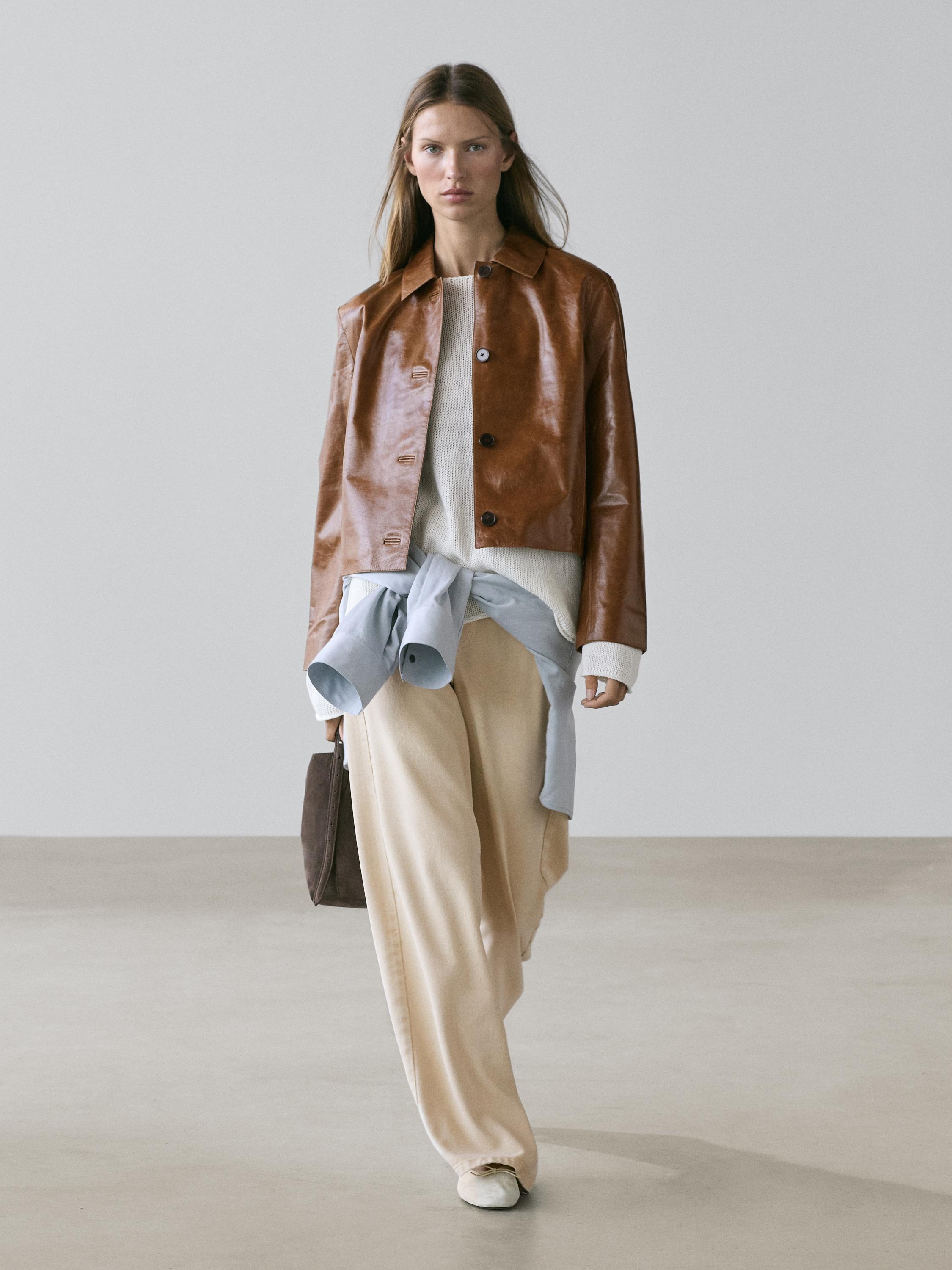 Camel bomber jacket set, white sweater, wide beige pants, and brown bag.