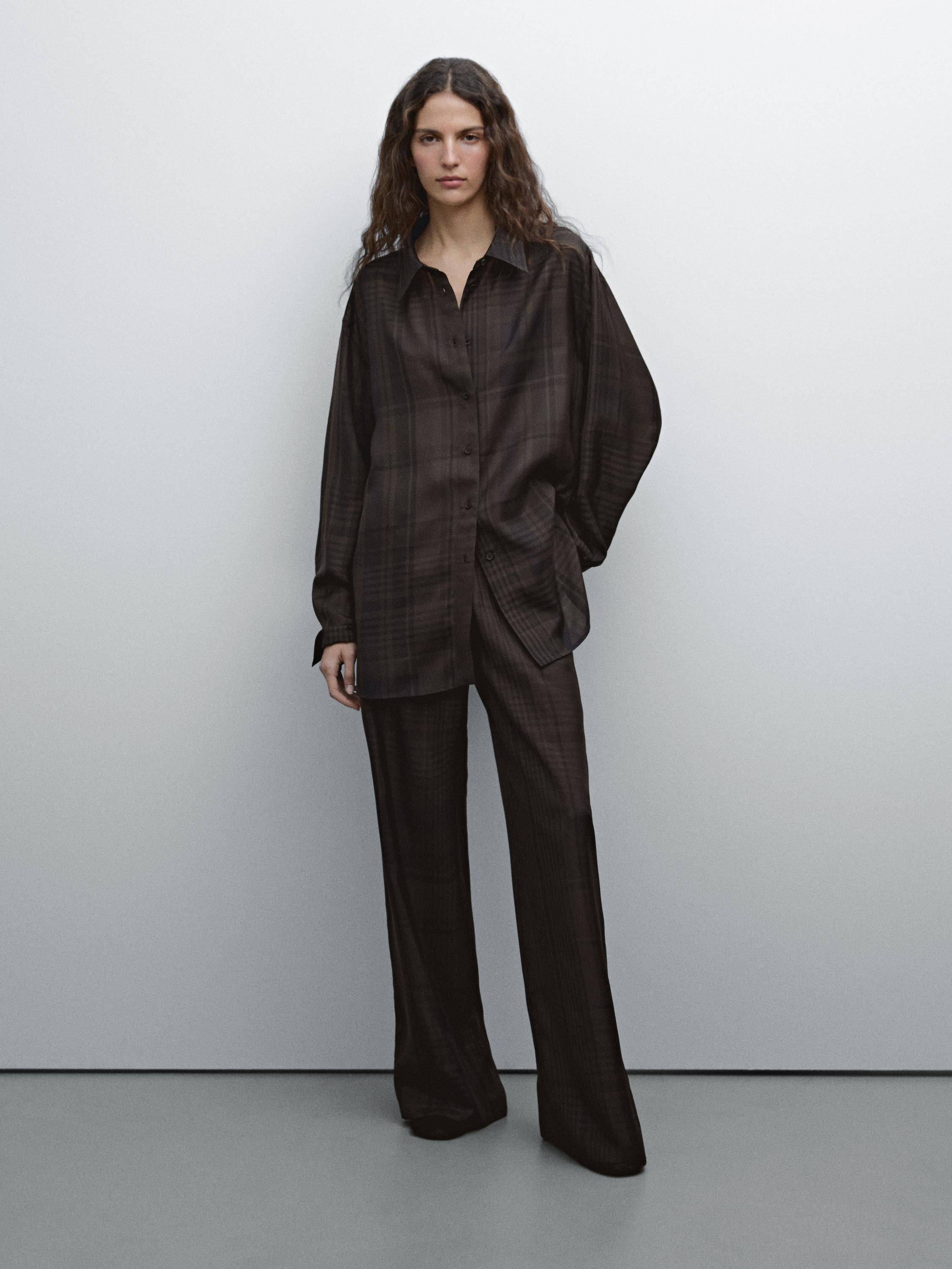 Conjunto de camisa y pantalón a cuadros en tonos oscuros.