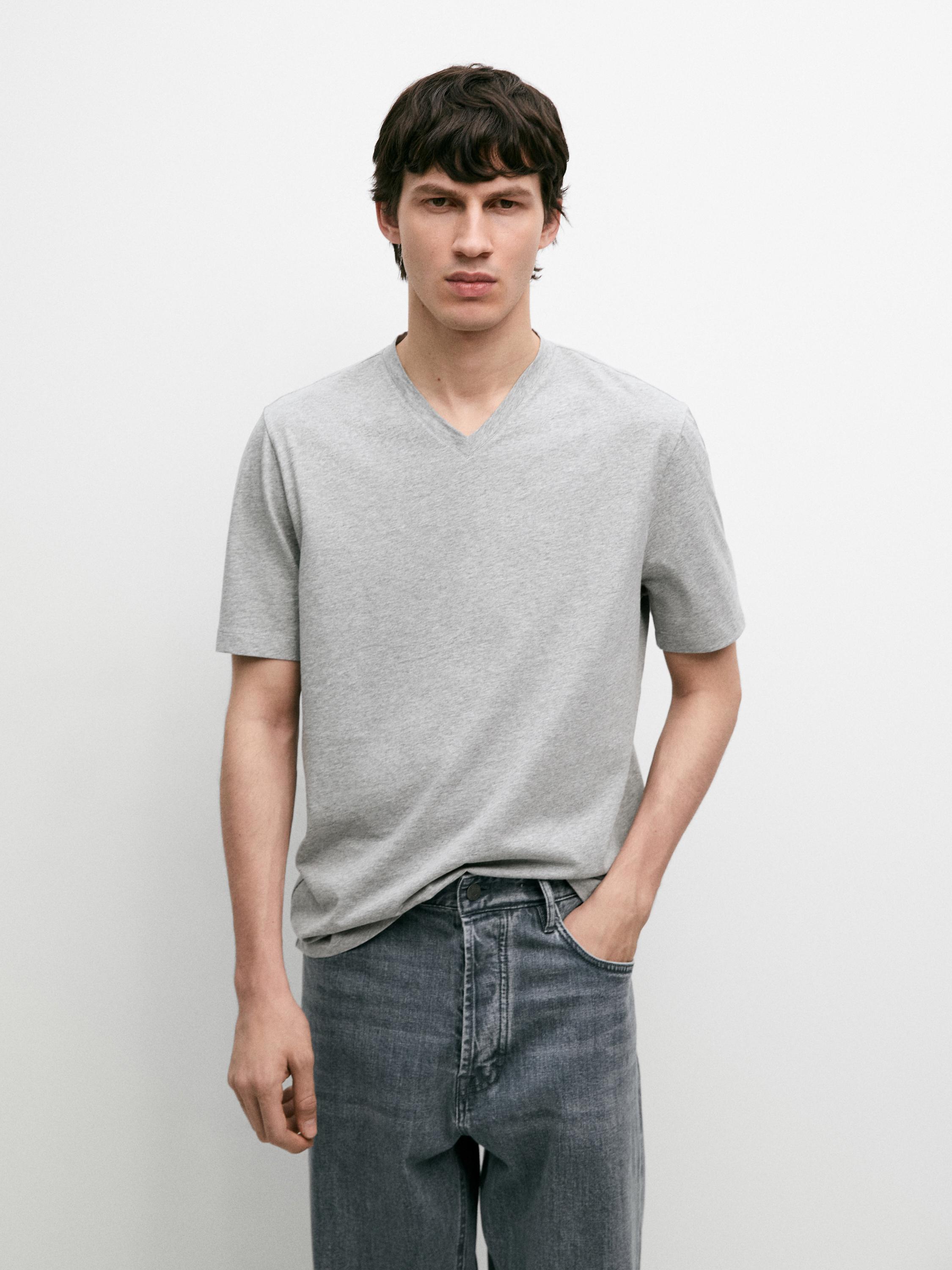 Σετ από γκρι μελανζέ κοντομάνικο T-shirt με V-λαιμόκοψη, συνδυασμένο με μπλε τζιν παντελόνι.