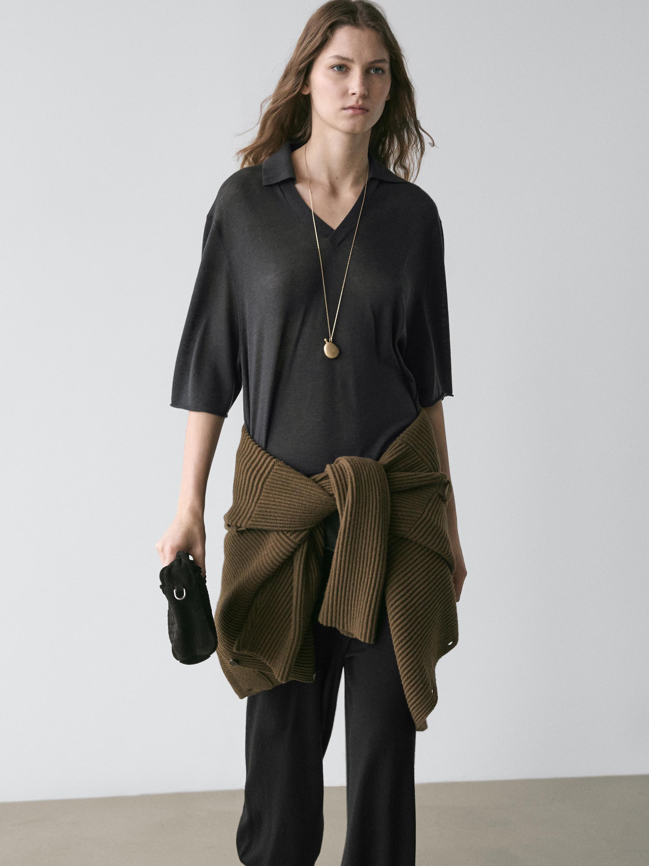 Oversize-Pullover-Set in Bleigrau mit V-Ausschnitt und schwarzer Hose. Brauner Pullover um die Taille gebunden.